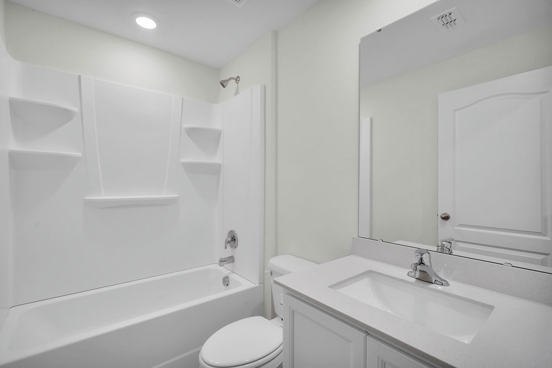 The spare bathroom has a tub and a large vanity