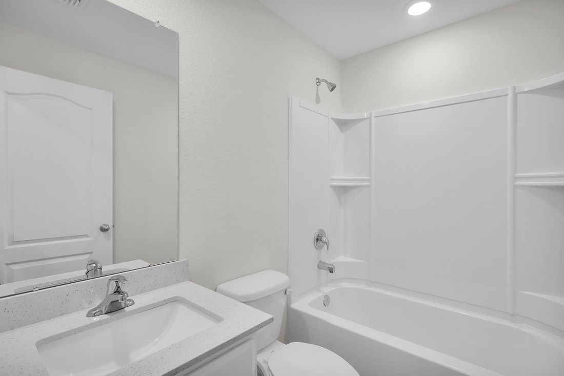 The spare bathroom has a large vanity and tub