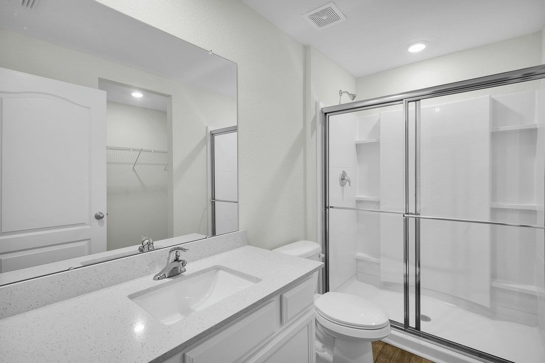 The master bathroom has a walk-in shower and spacious vanity