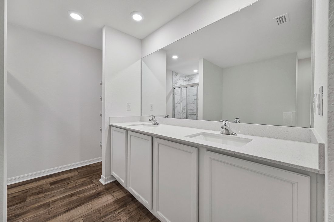The master bathroom has a spacious two sink vanity, linen closet, walk-in shower, and a tub