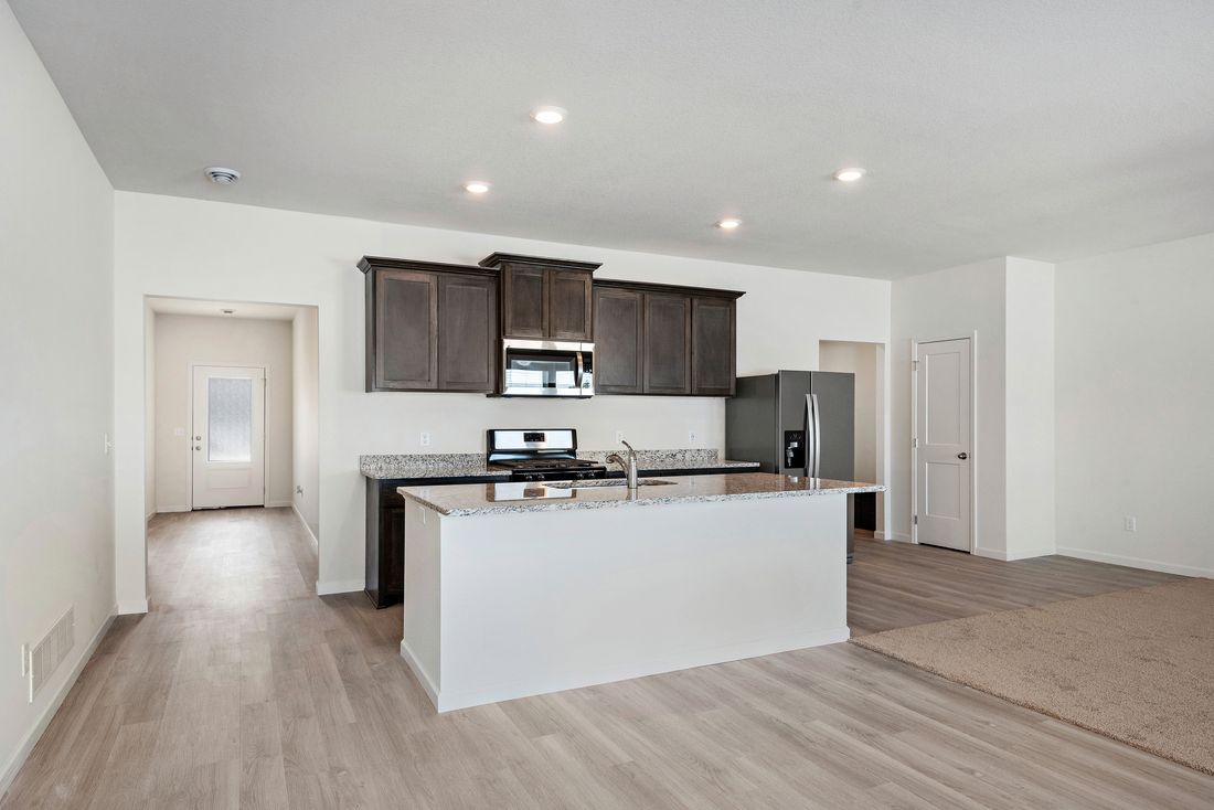The kitchen has a large island that overlooks the entertainment space