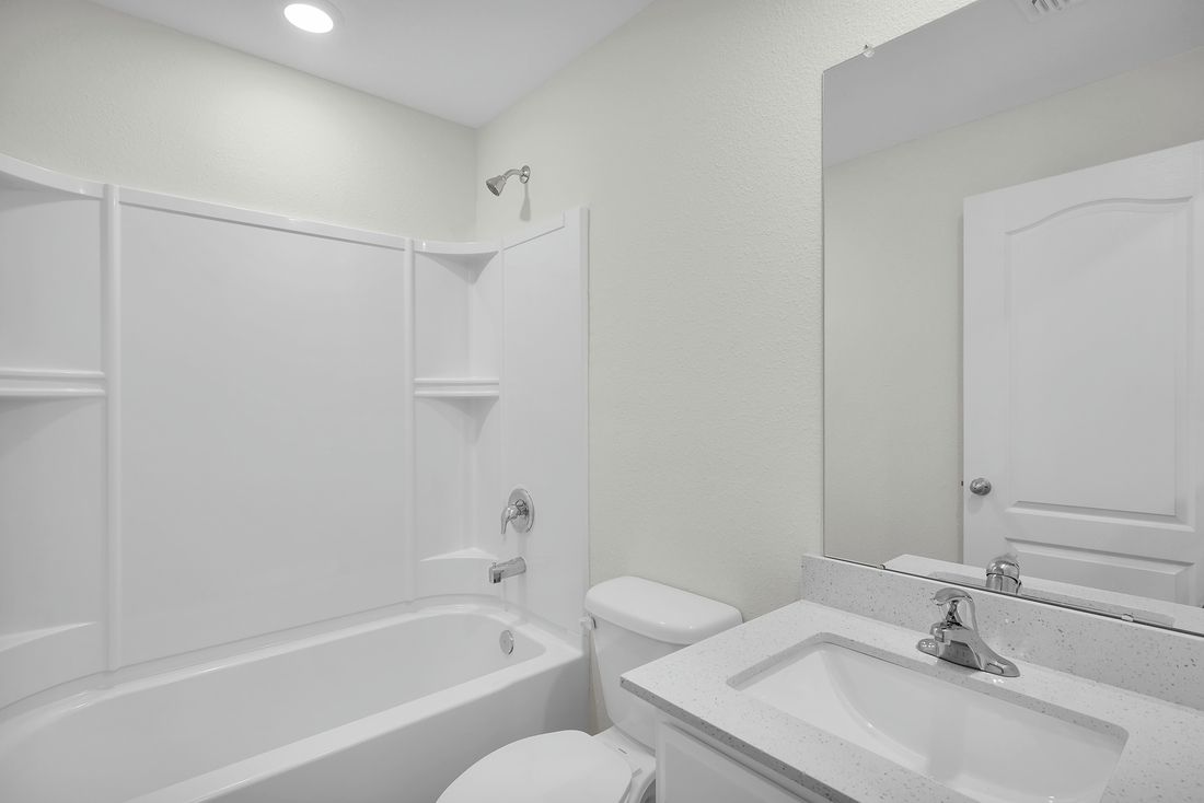 The spare bathroom has a large vanity and tub