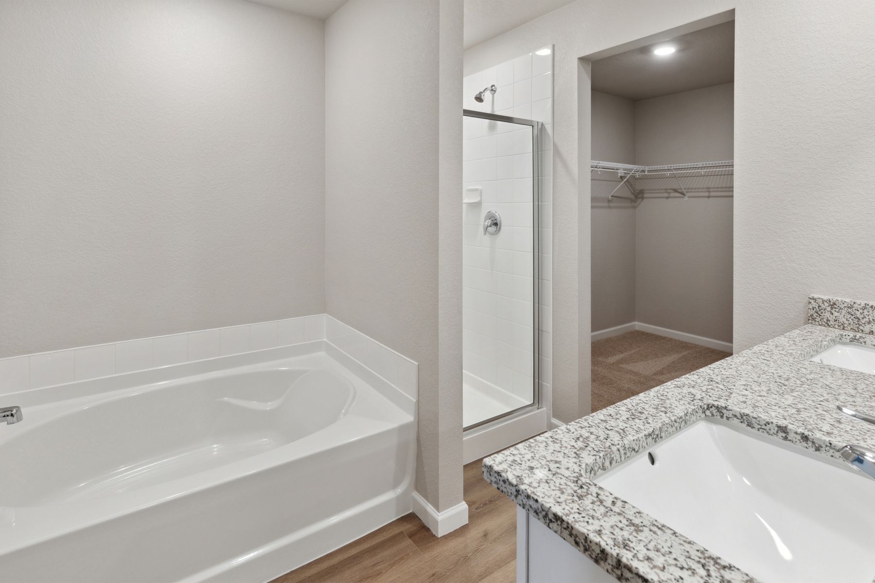 The master bathroom of the Yale floor plan has a large garden tub, glass shower, and large vanity space.