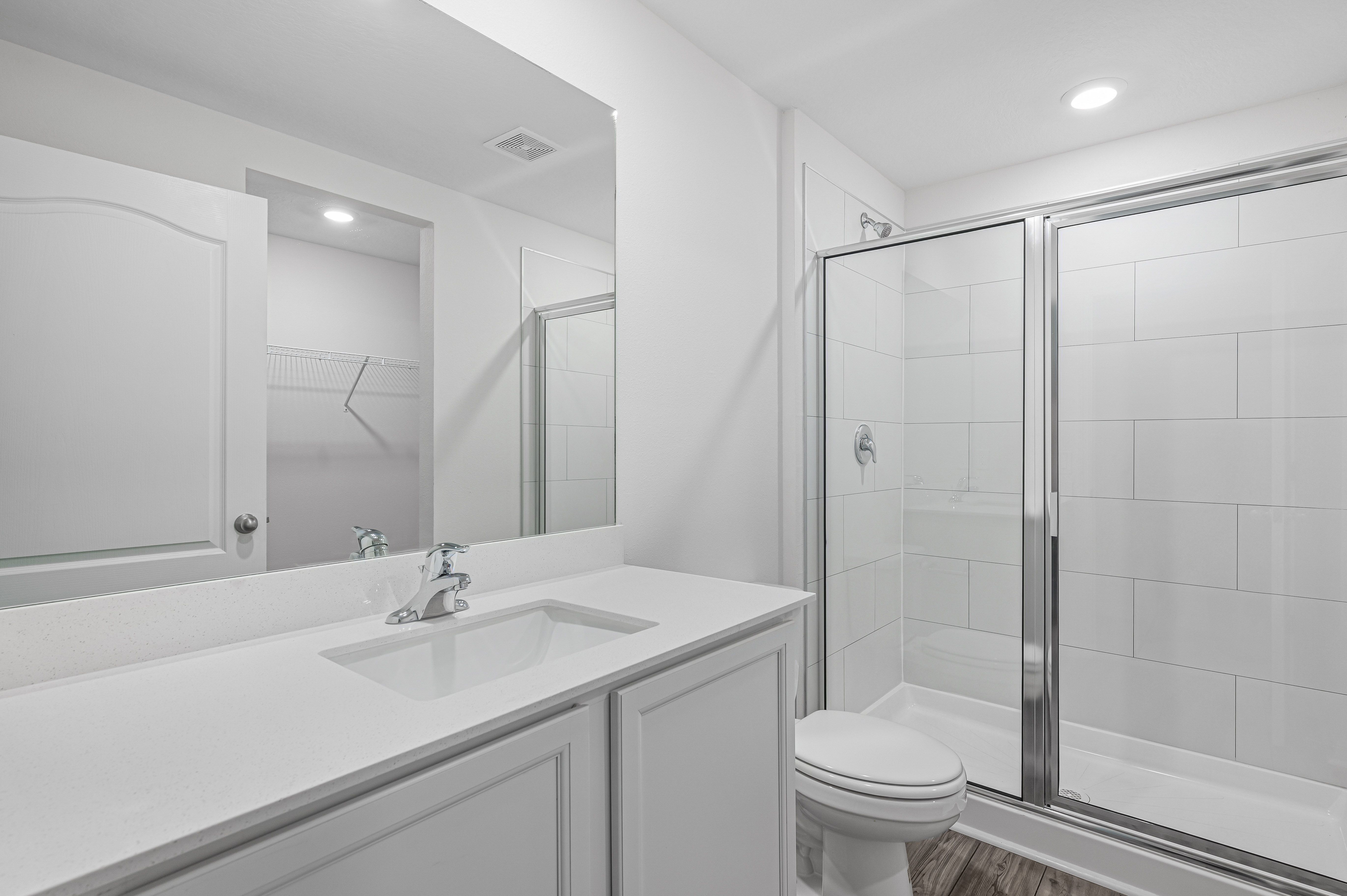 The master bathroom has a walk-in shower and spacious vanity