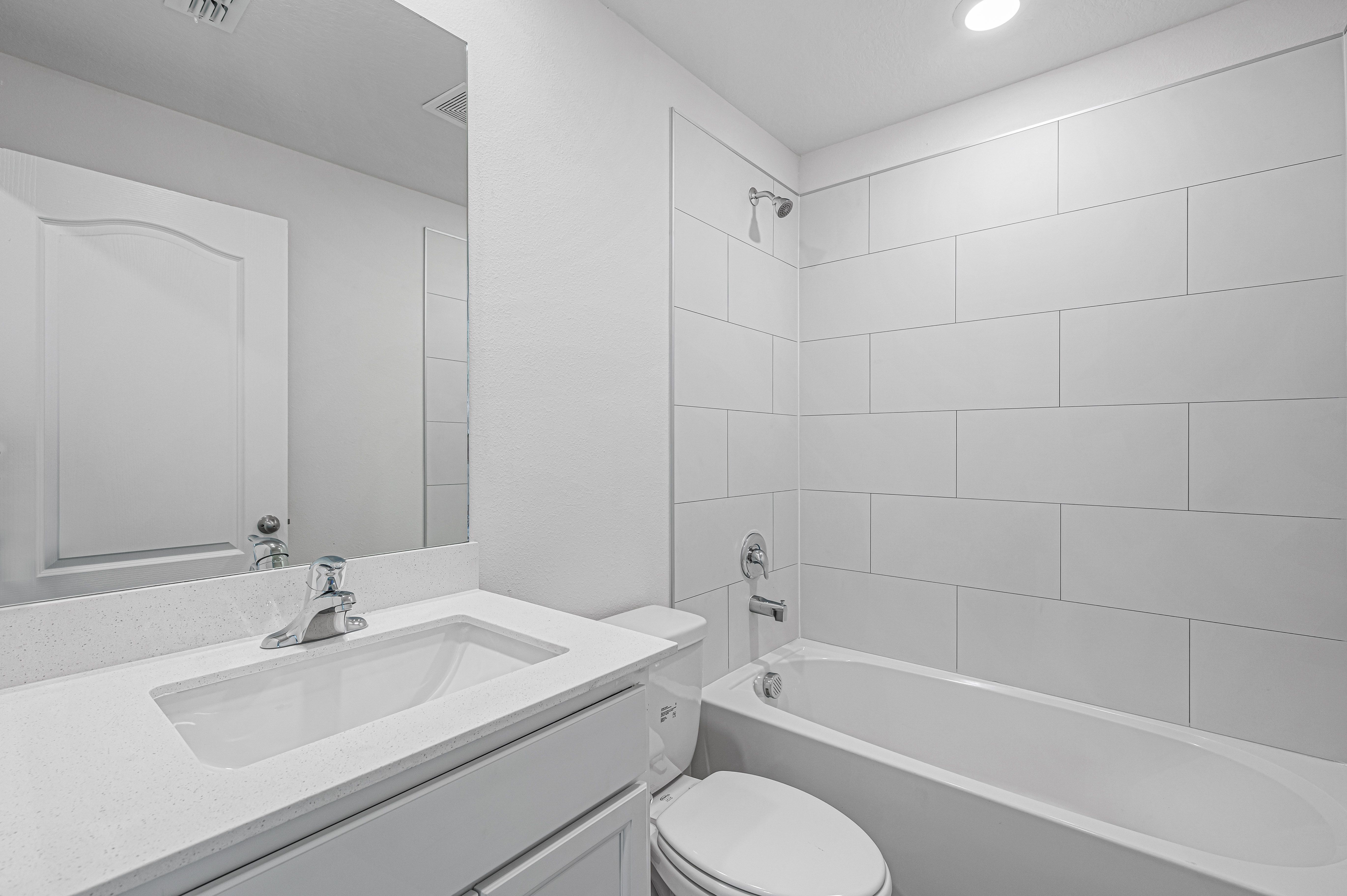 The spare bathroom has a large vanity and tub