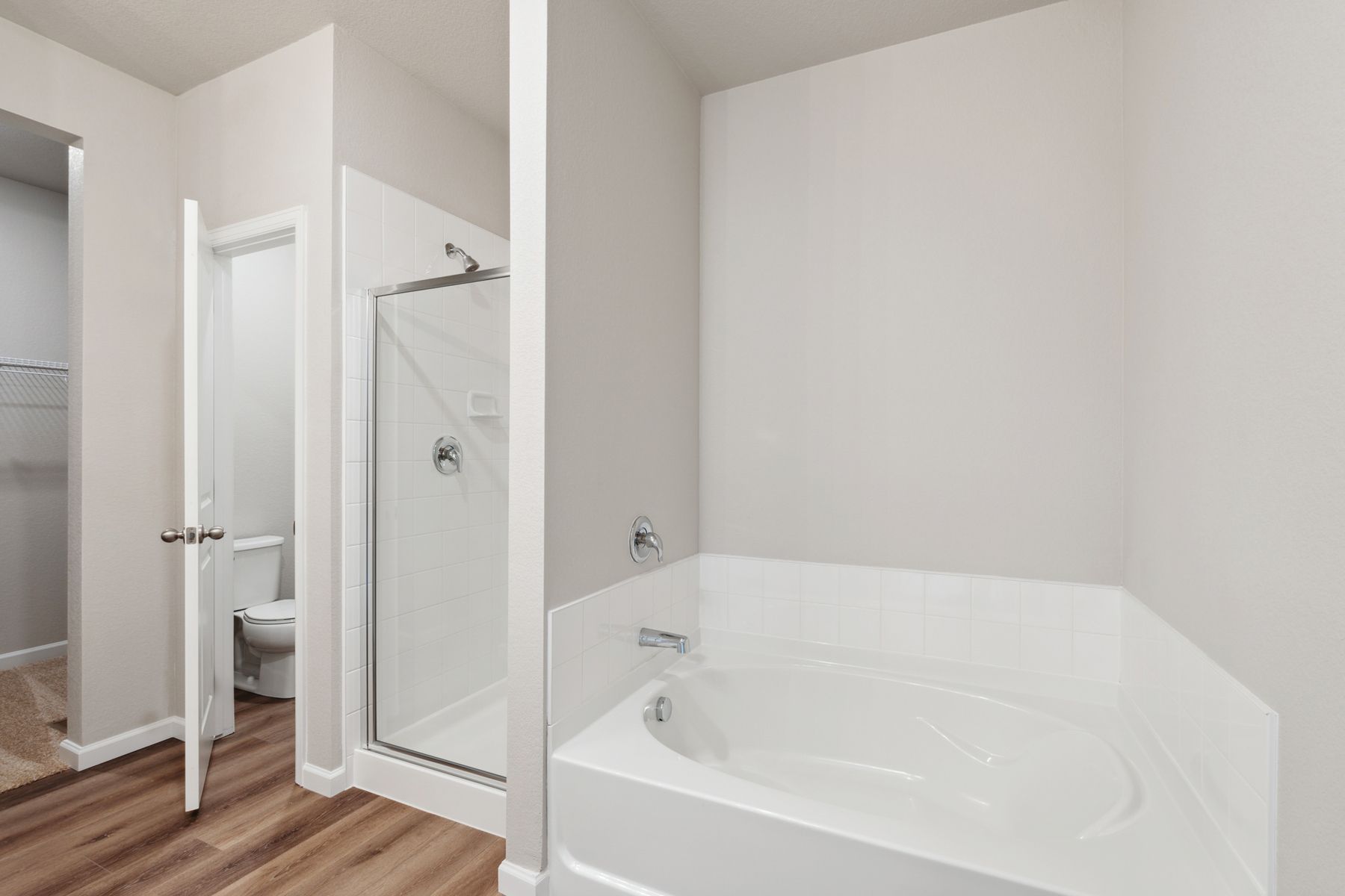 The master bathroom has a large garden tub and walk-in, glass shower.