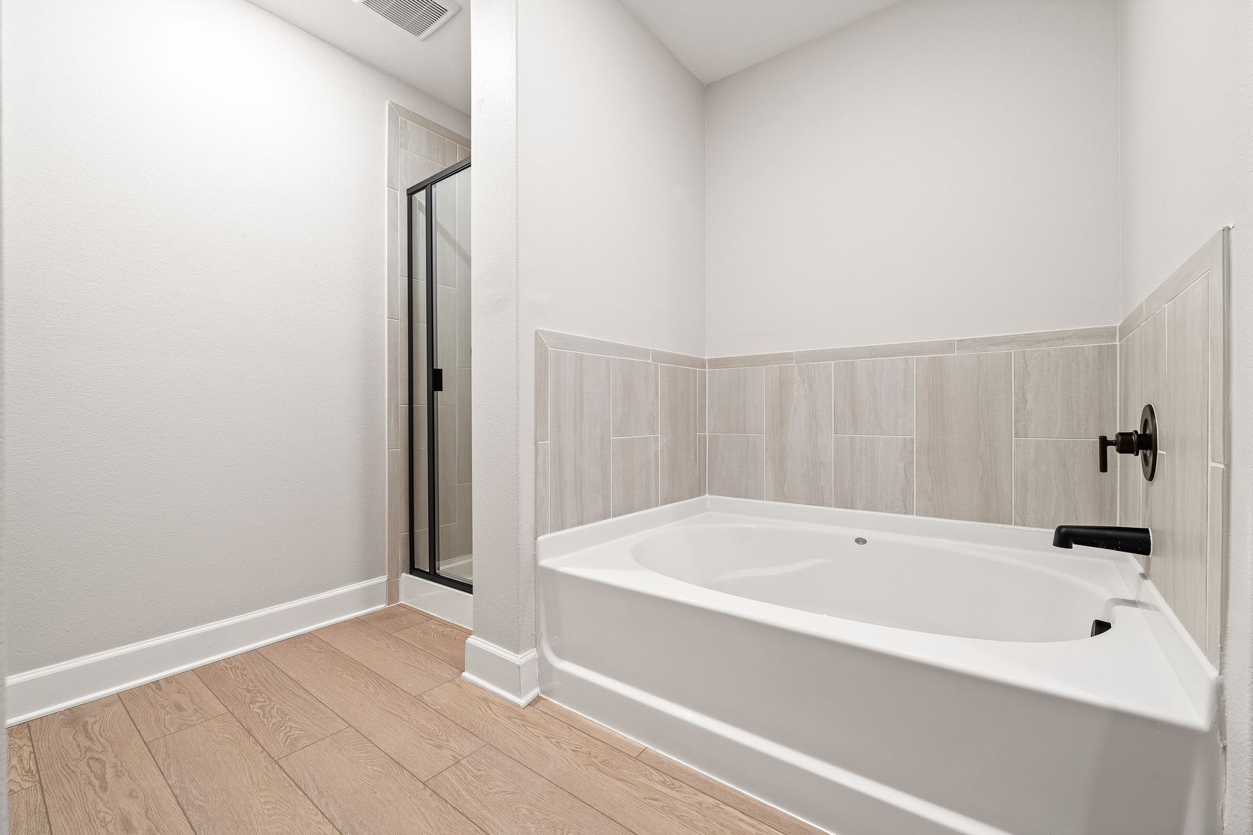 The master bathroom of the Rayburn has a garden tub and walk-in, glass shower.