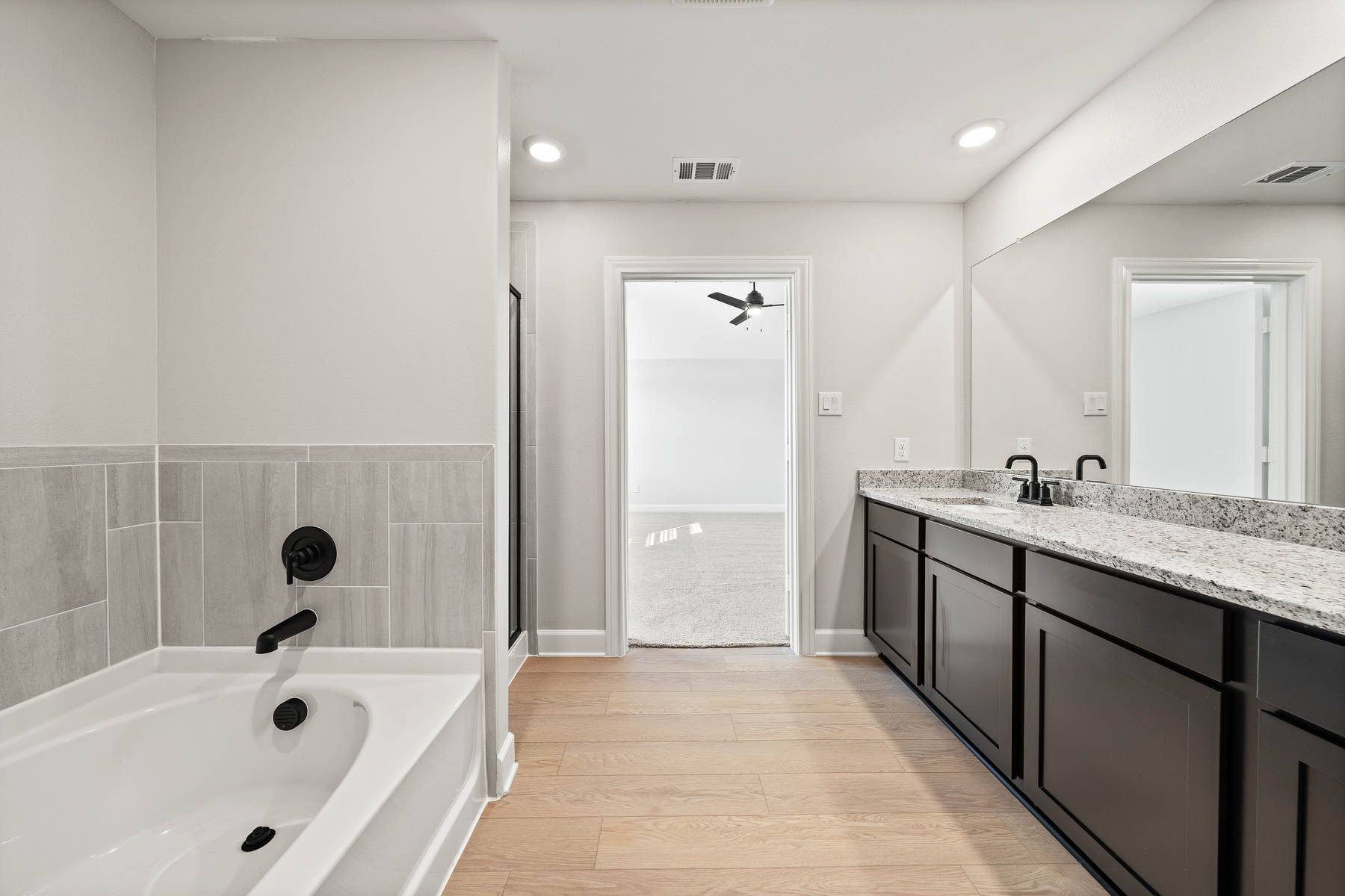 The master bathroom has a garden tub and glass, walk-in shower.