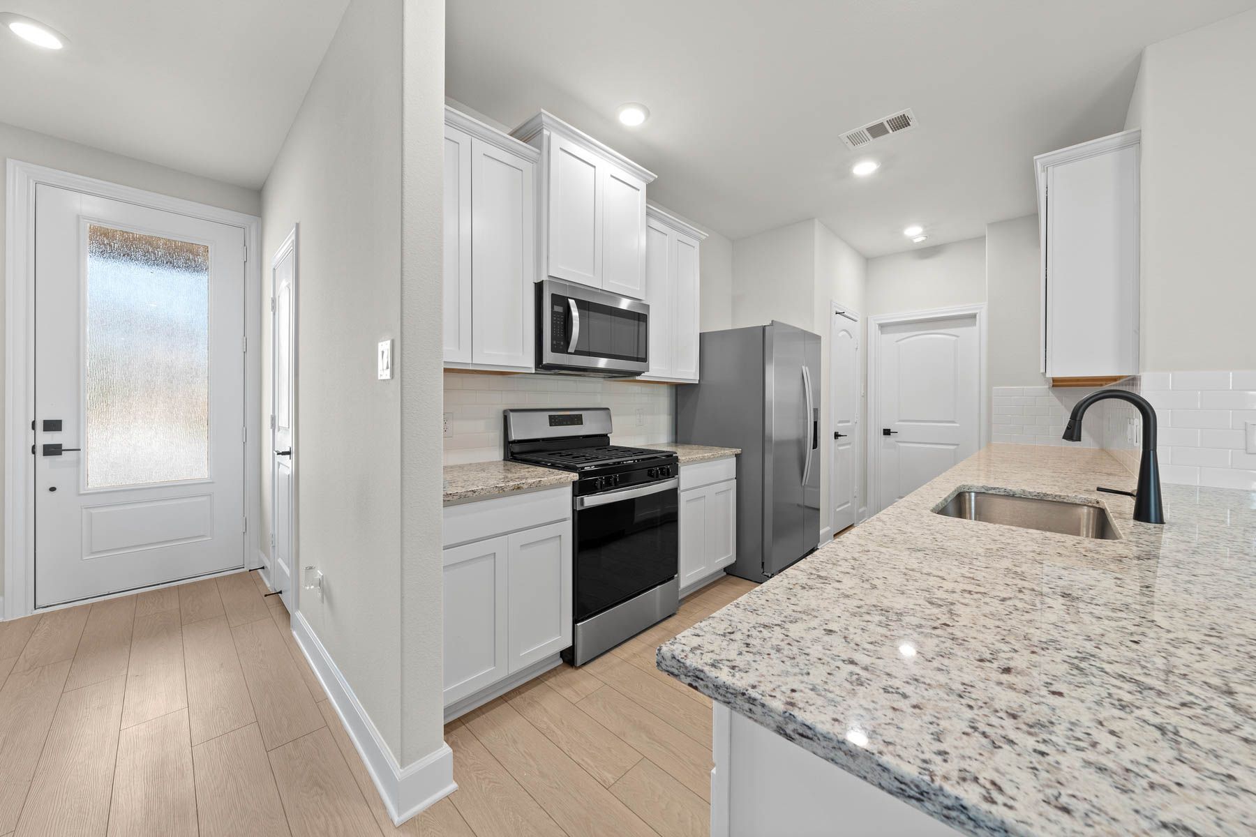 The kitchen of the Cedar has beautiful white wood cabinets.