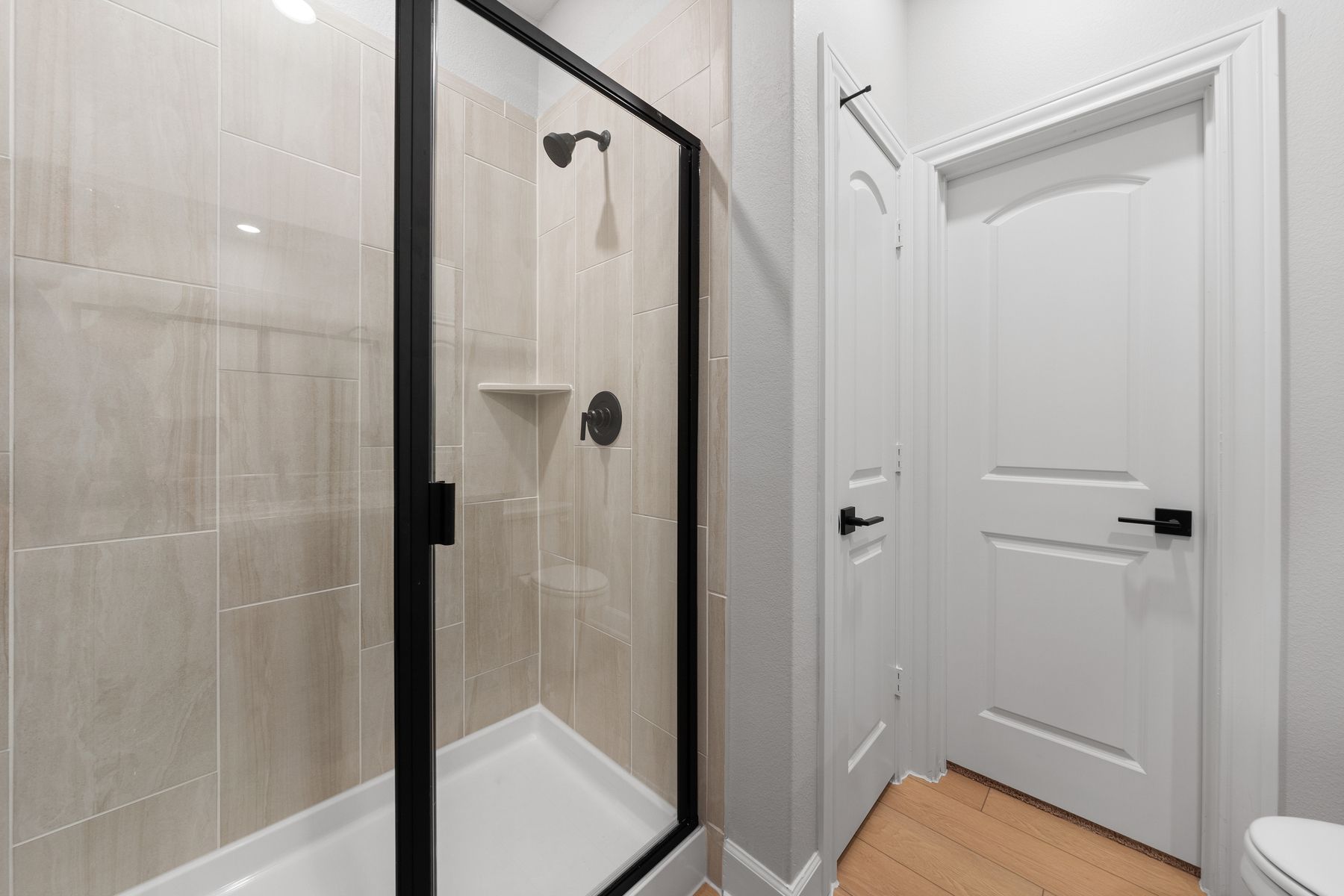The master bathroom of the Piper has a beautifully tiled walk-in, glass shower.