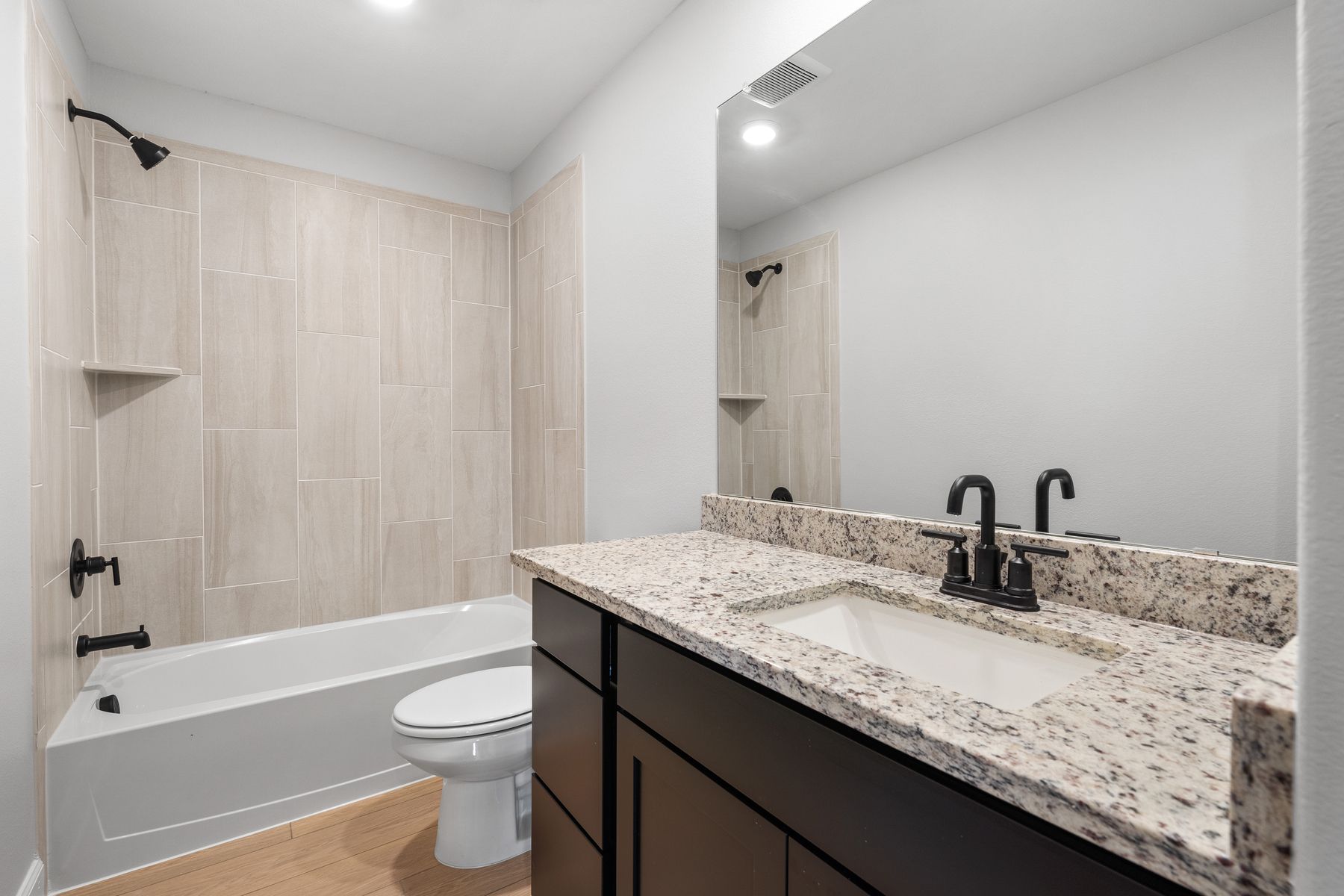 The secondary bathroom in the Piper has a large vanity and tiled shower-tub combo.
