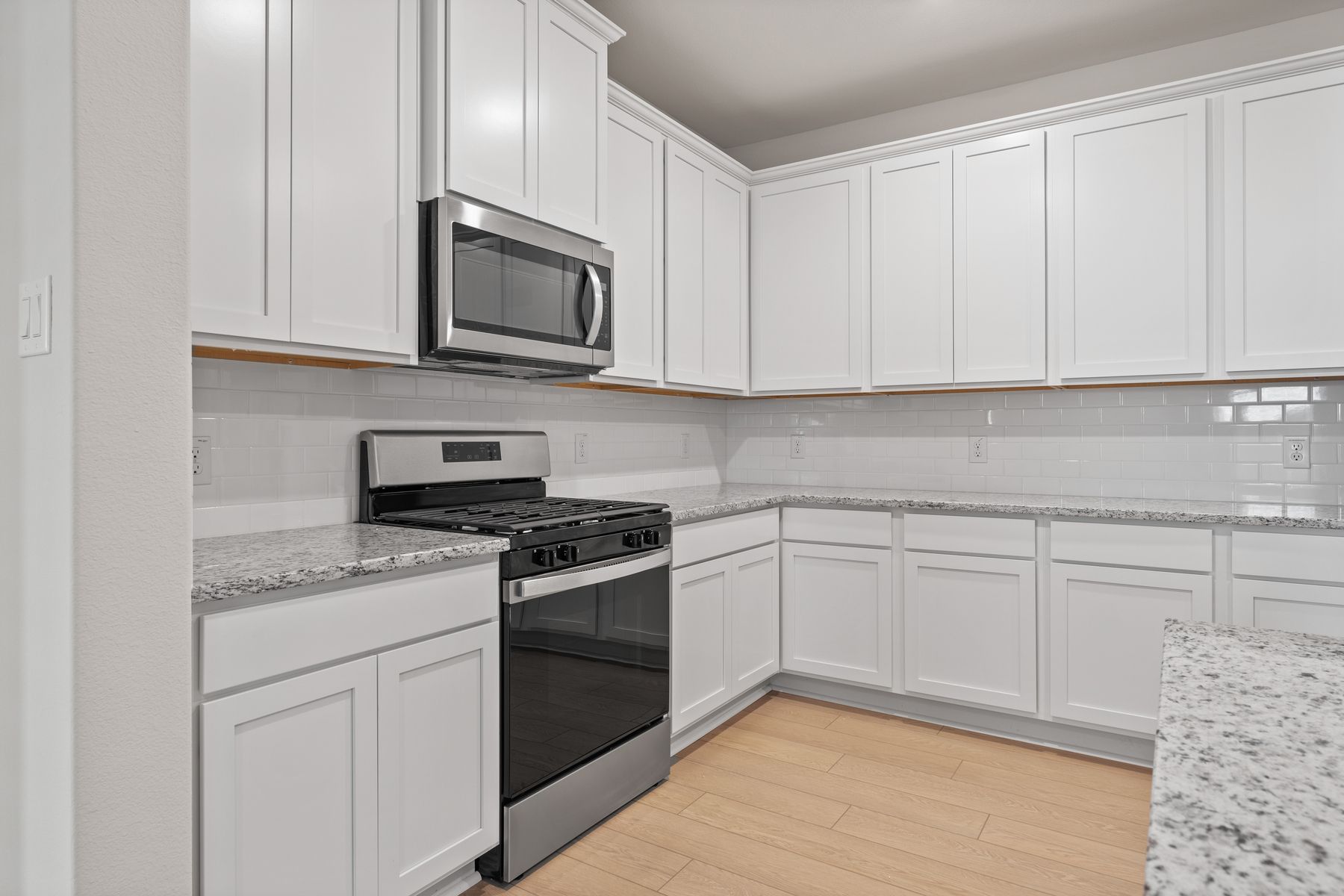 The kitchen of the Willow has white wood cabinets.