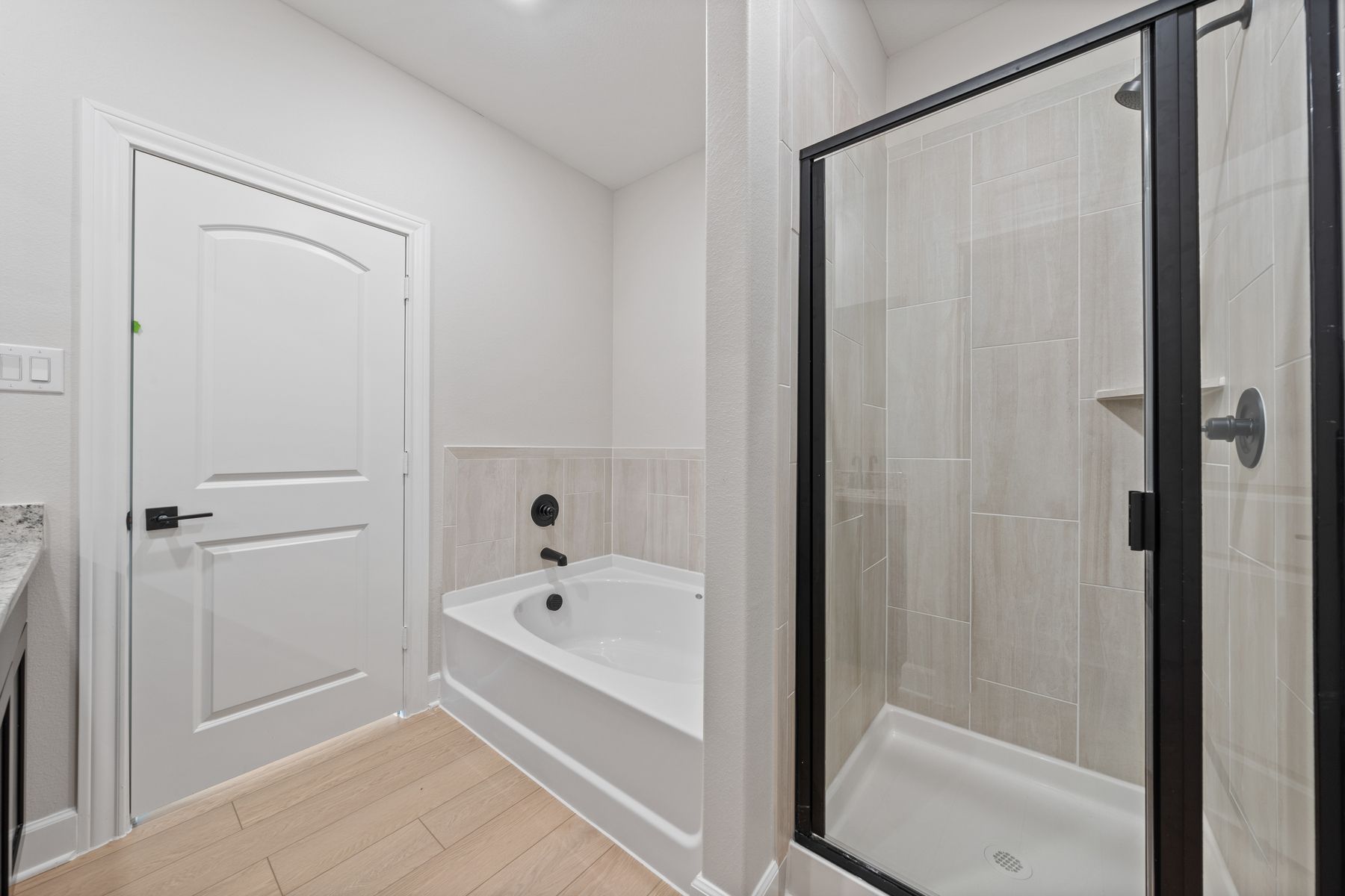 The master bathroom has a walk-in, glass shower and a garden tub.