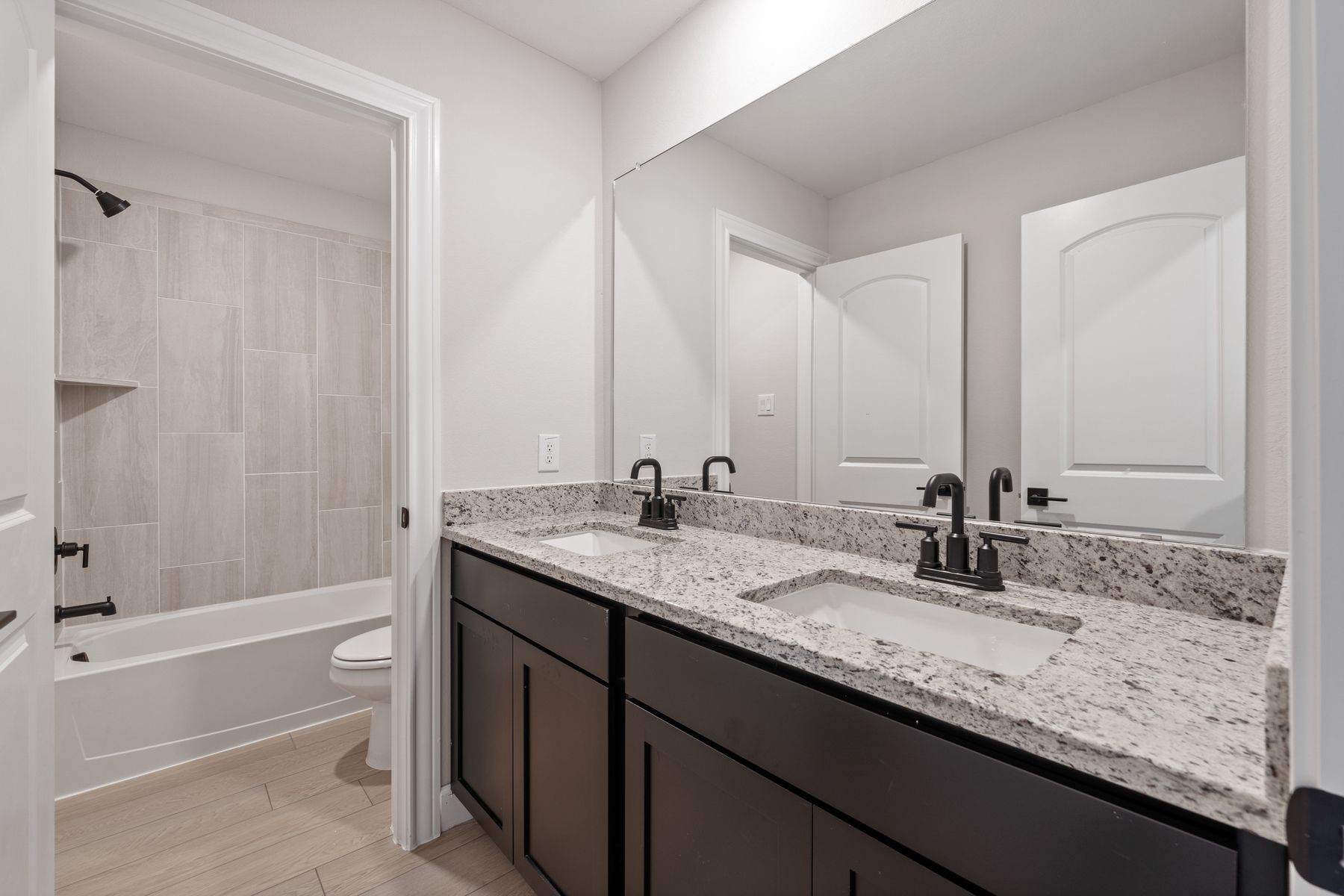 The secondary bathroom has dual sinks and a seperate room for the shower-tub combo and toilet.