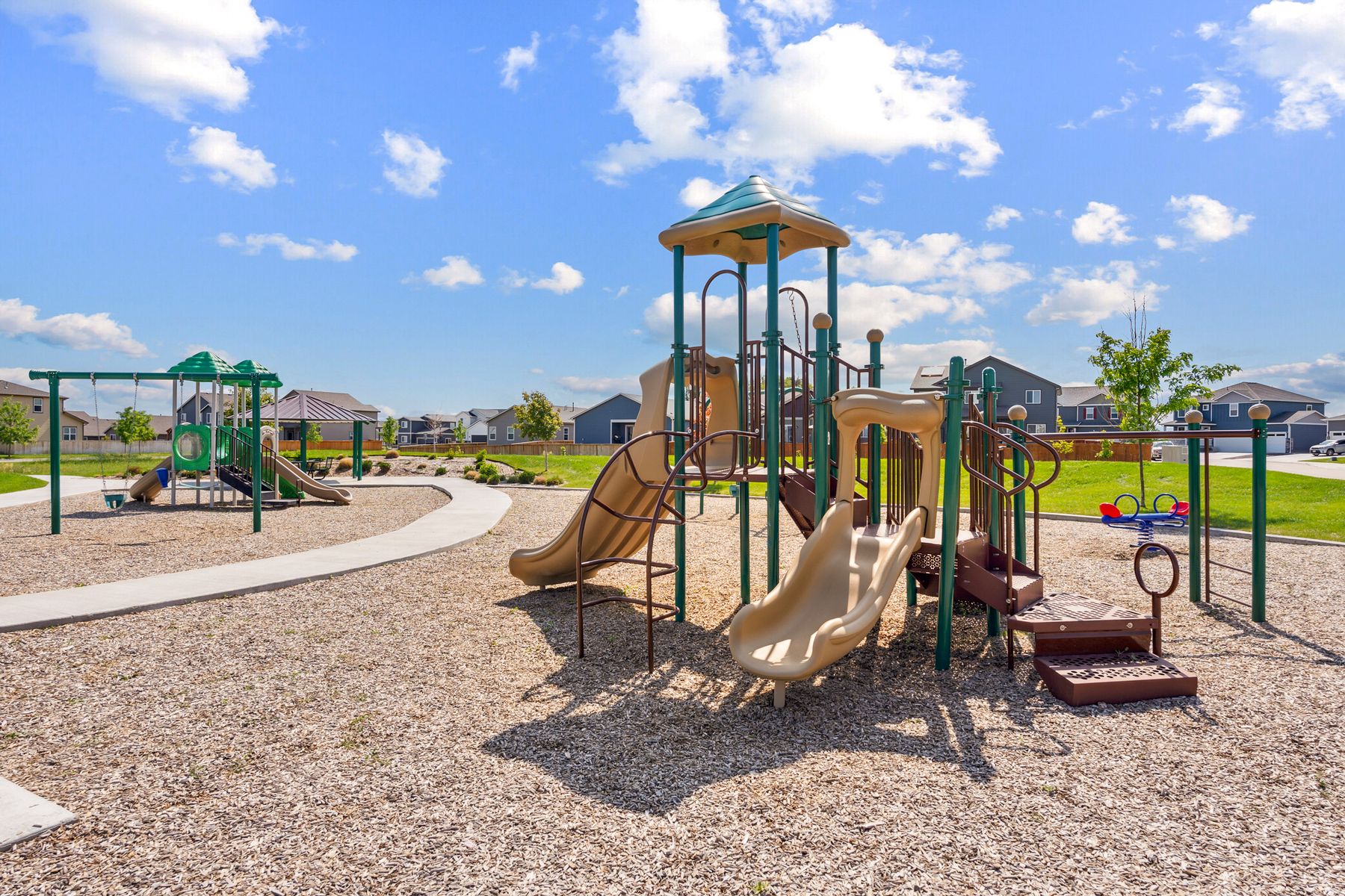 There is a kids playground and a swing set here.