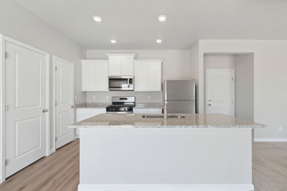 The kitchen of the Laramie has beautiful white wood cabinets.