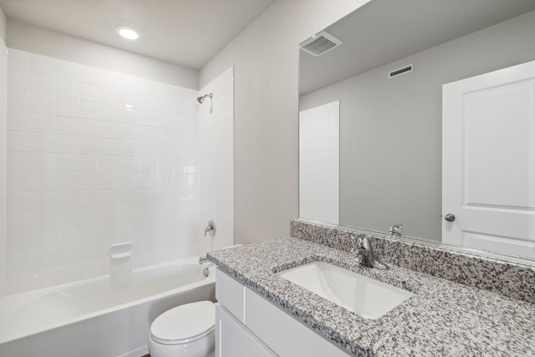 The secondary bathroom has a large vanity space and a shower-tub combo.
