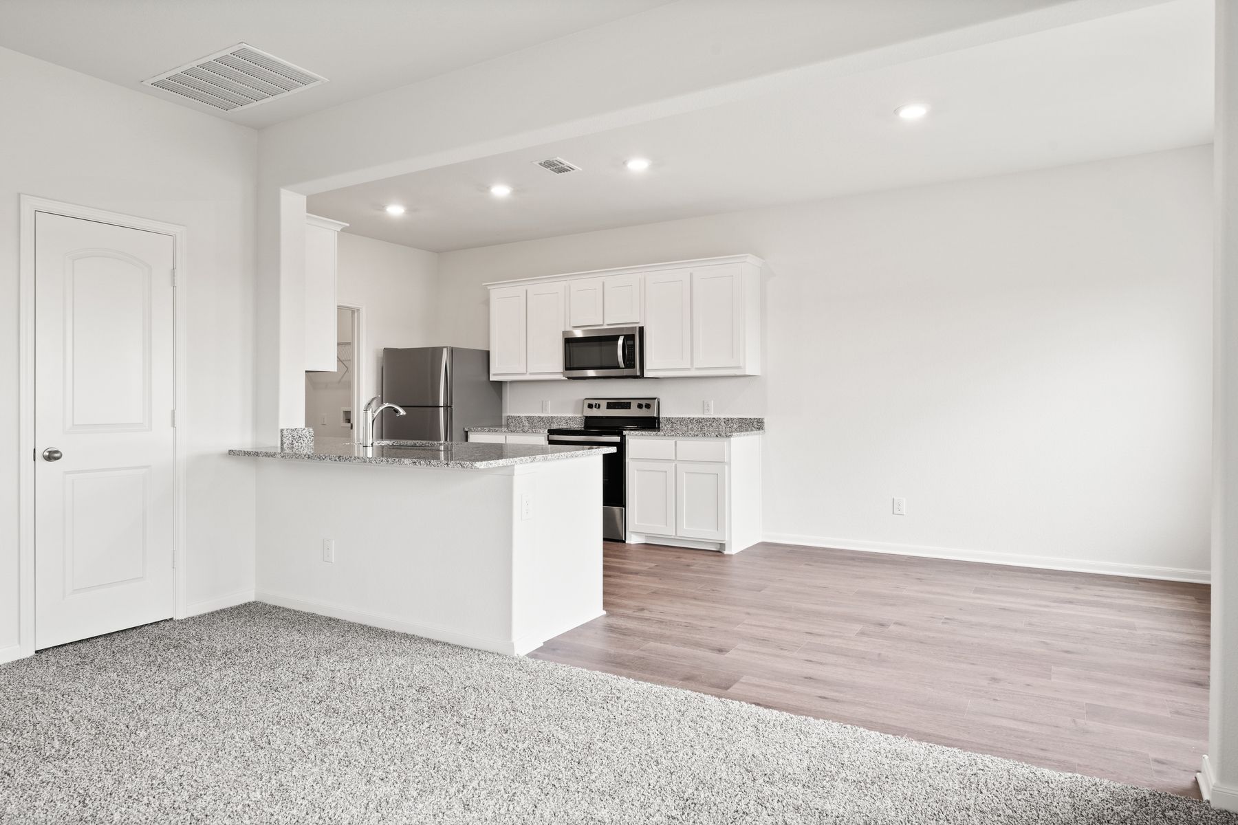 The kitchen of the Cypress has beautiful white wood cabinets.