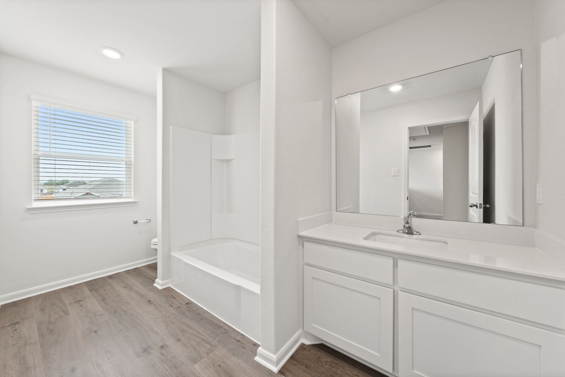 The secondary bathroom of the Cypress has a large vanity and a shower-tub combo.