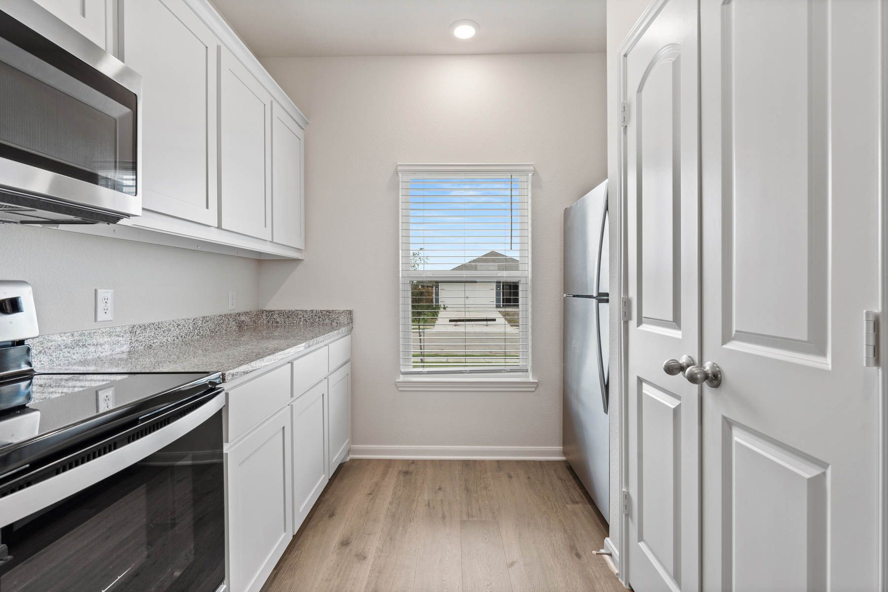 The kitchen of the Driftwood has beautiful white wood cabinets.