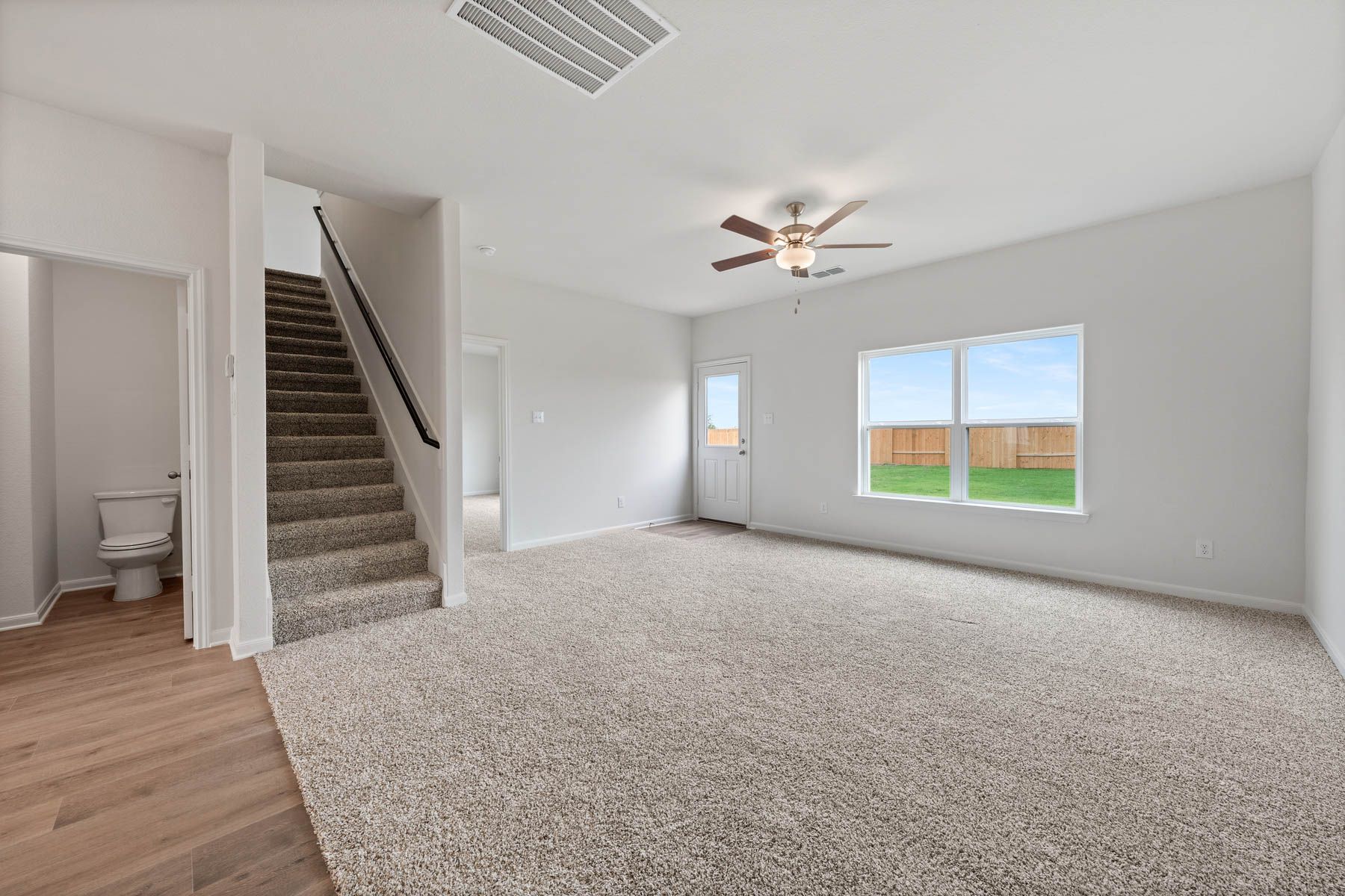 The large family room of the Driftwood has a large window with backyard views.