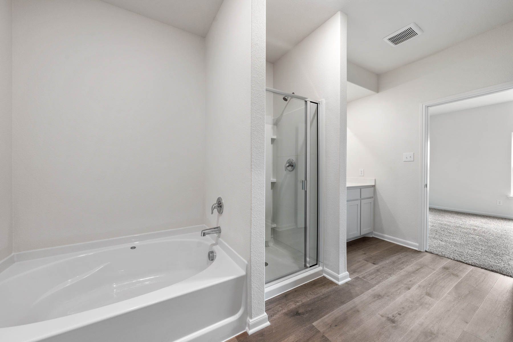 The master bathroom of the Driftwood has a glass, walk-in shower and garden tub.