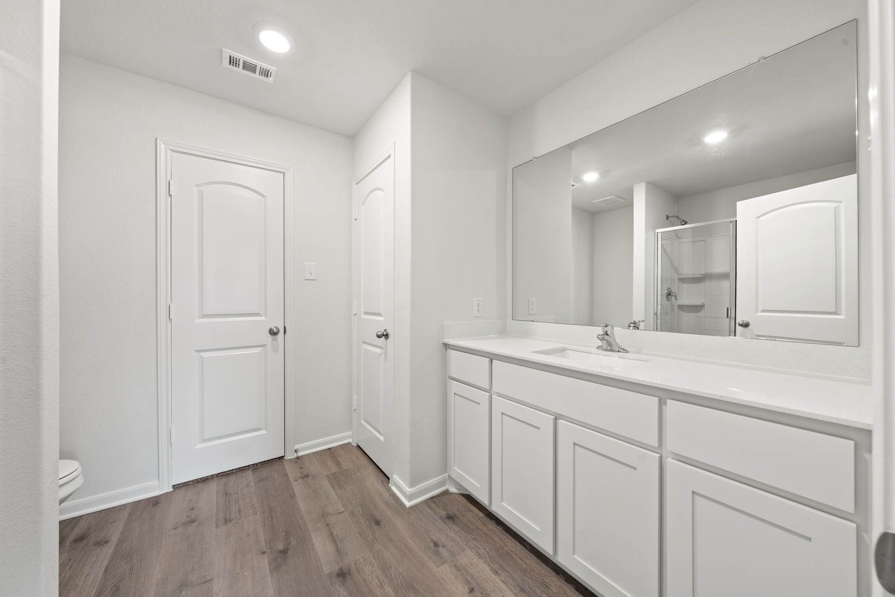 The master bathroom has a large vanity with plenty of counterspace.