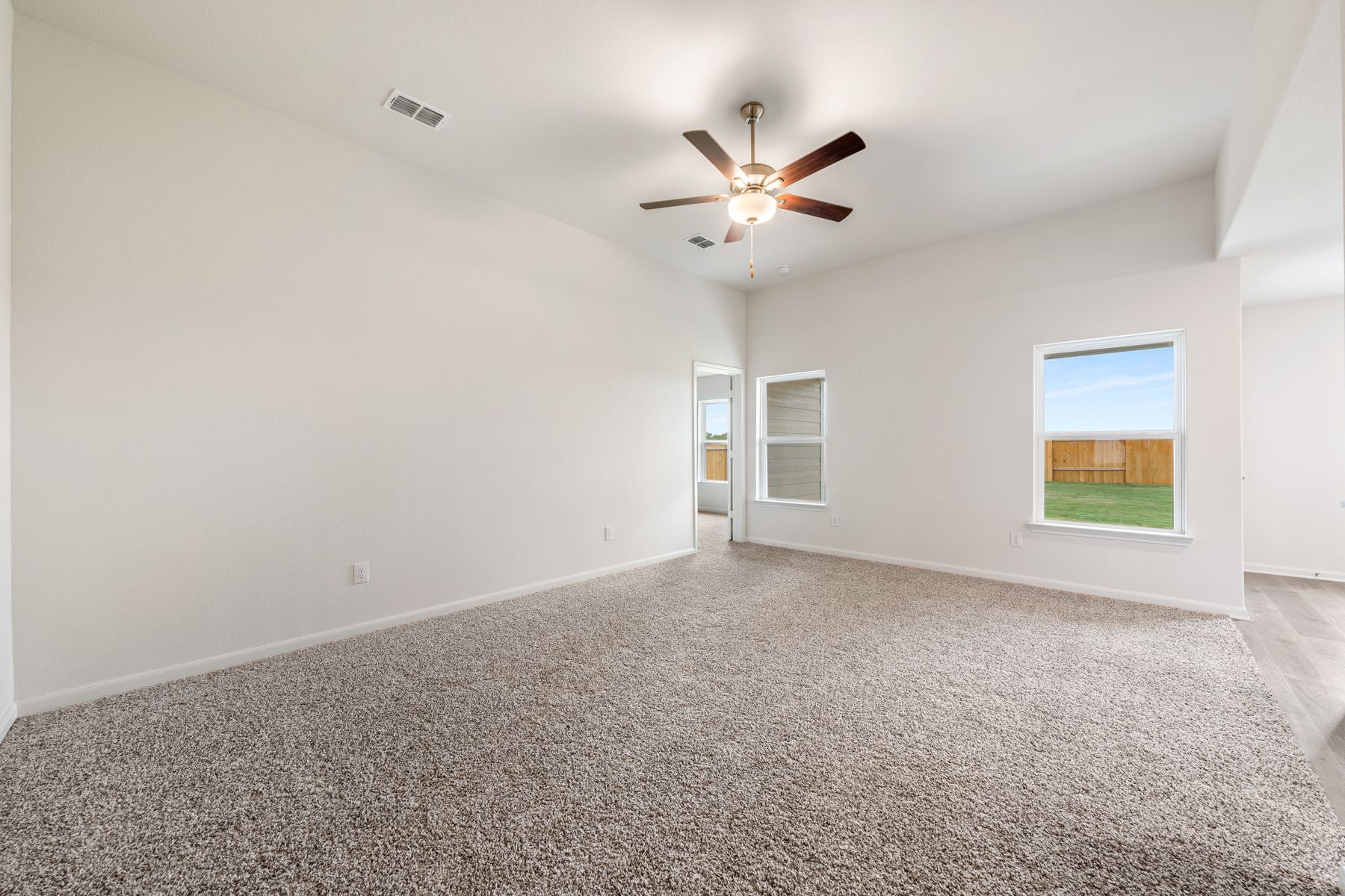 The family room of the Blanco has large windows that let in great natural light and back yard views.