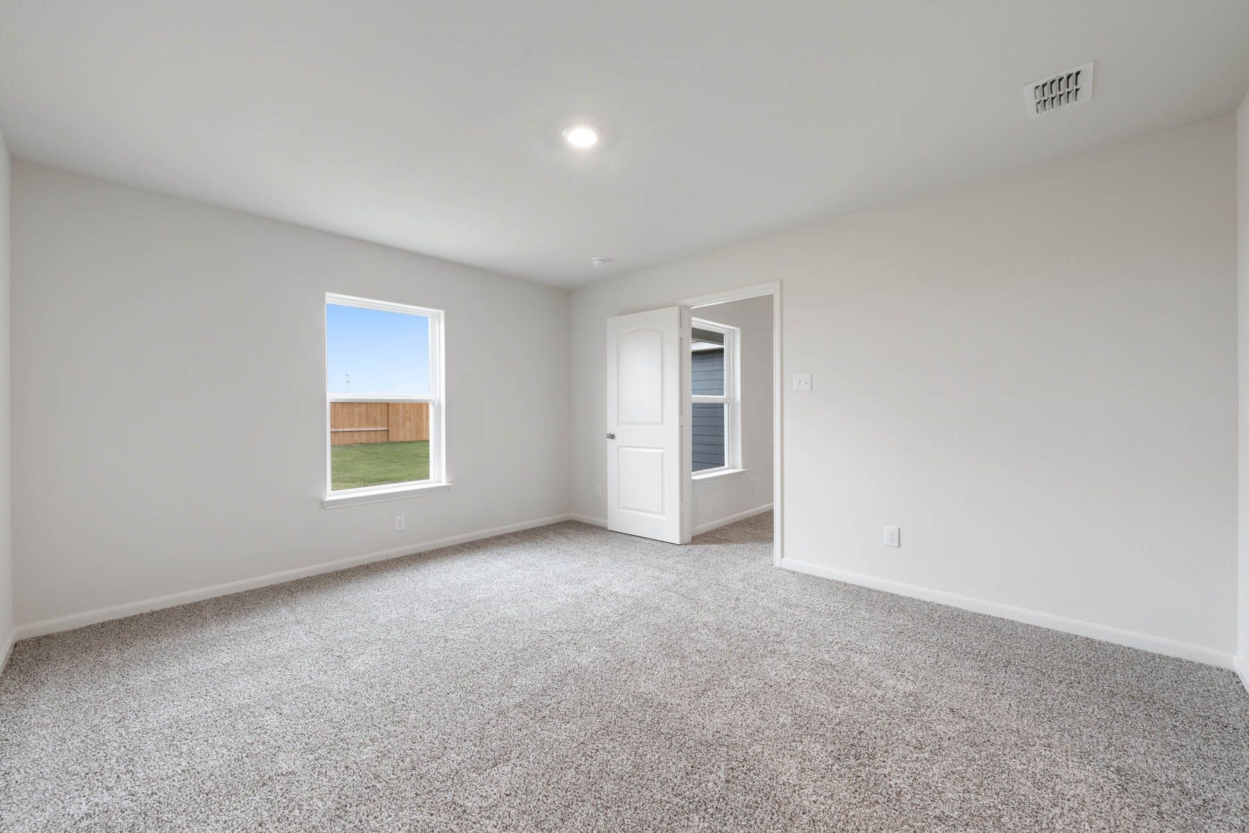 The master suite has a large window with backyard views.