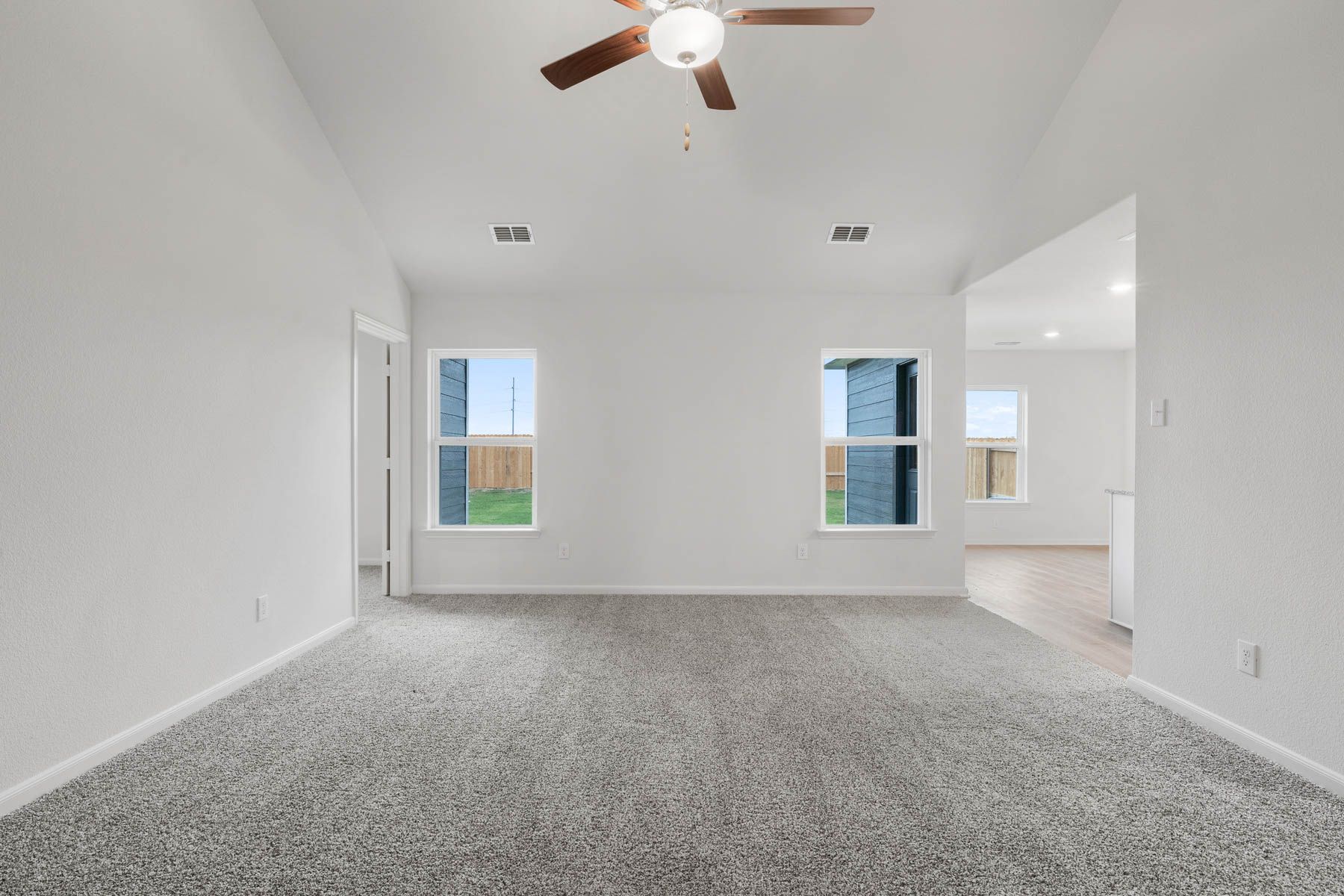 The family room of the Sabine has two windows with a backyard view.