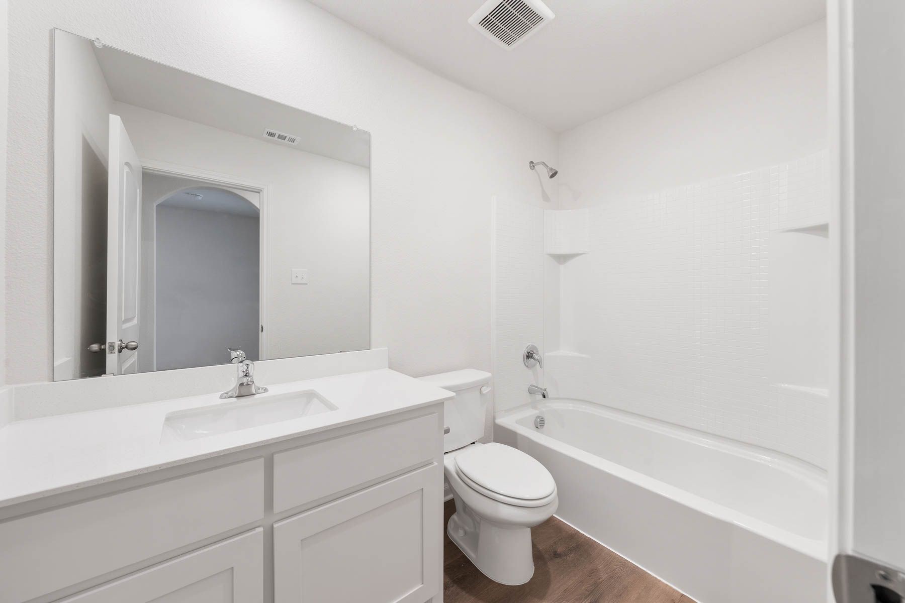 The secondary bathroom has a large vanity space and a shower-tub combo.