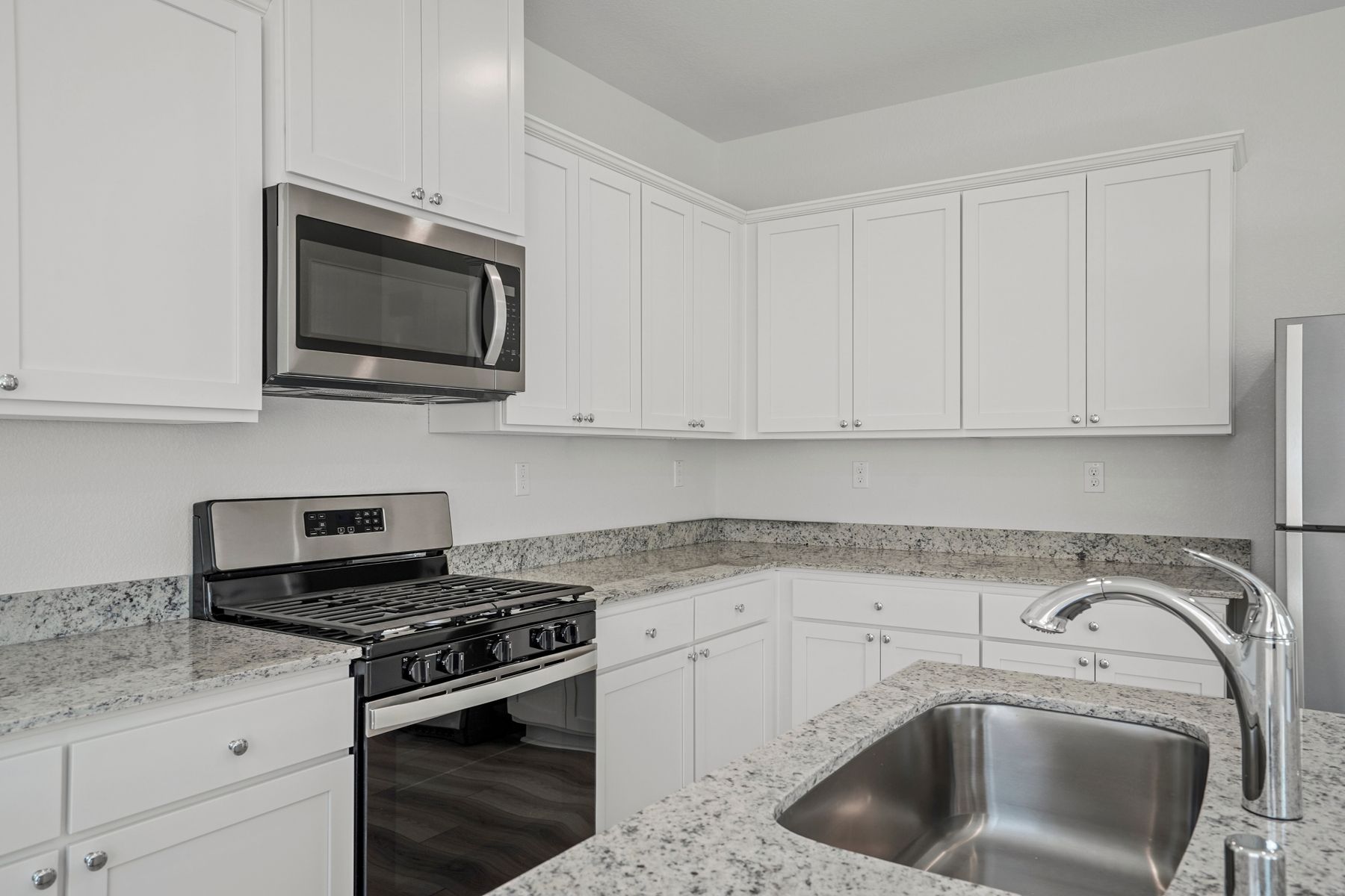 Enjoy stunning granite countertops in this radiant kitchen area.