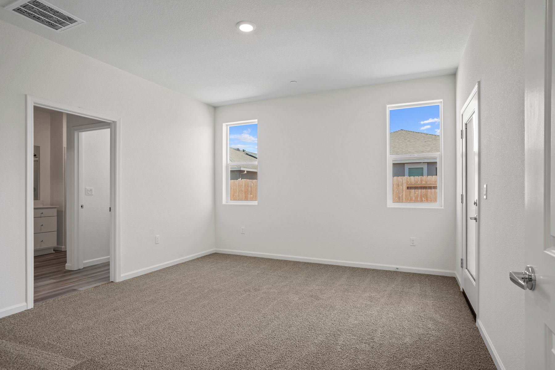 Windows let in plenty of natural light to this master bedroom.