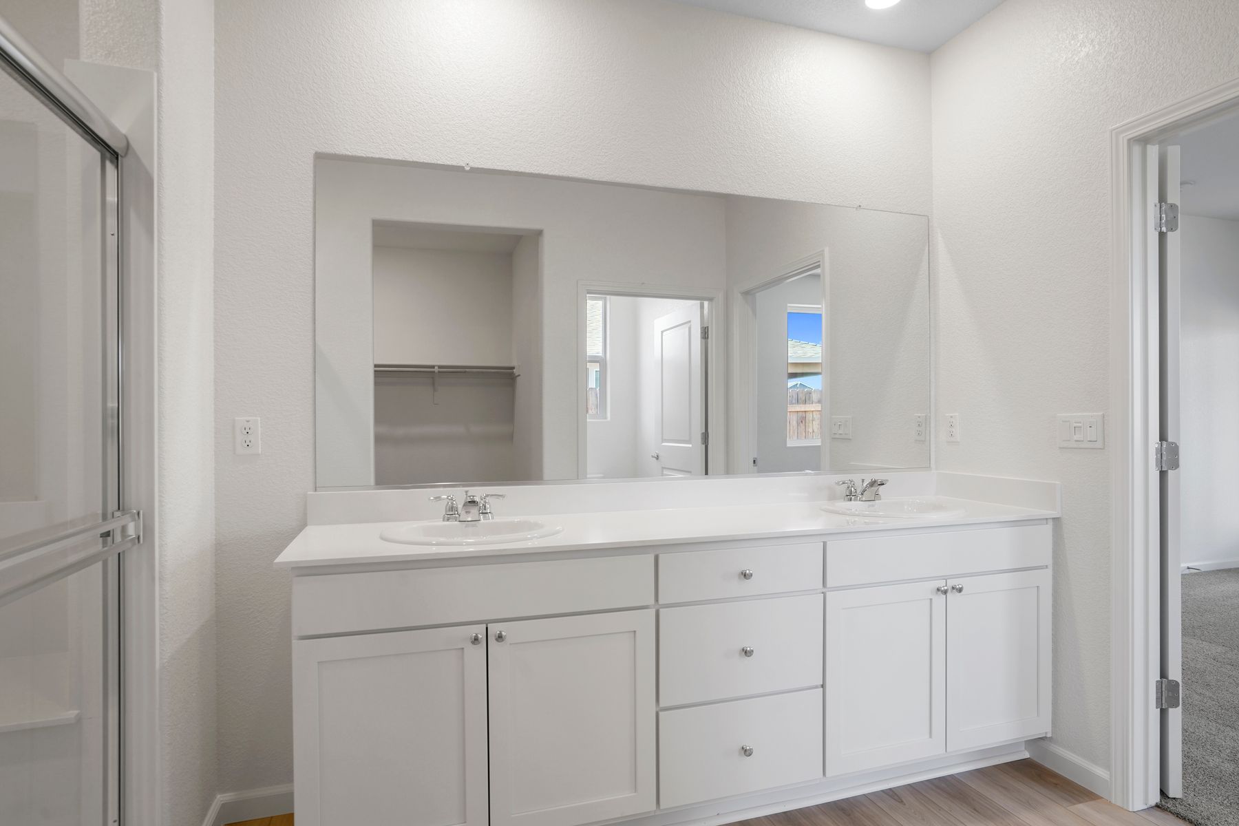 This bathroom has two sinks along with a large shower