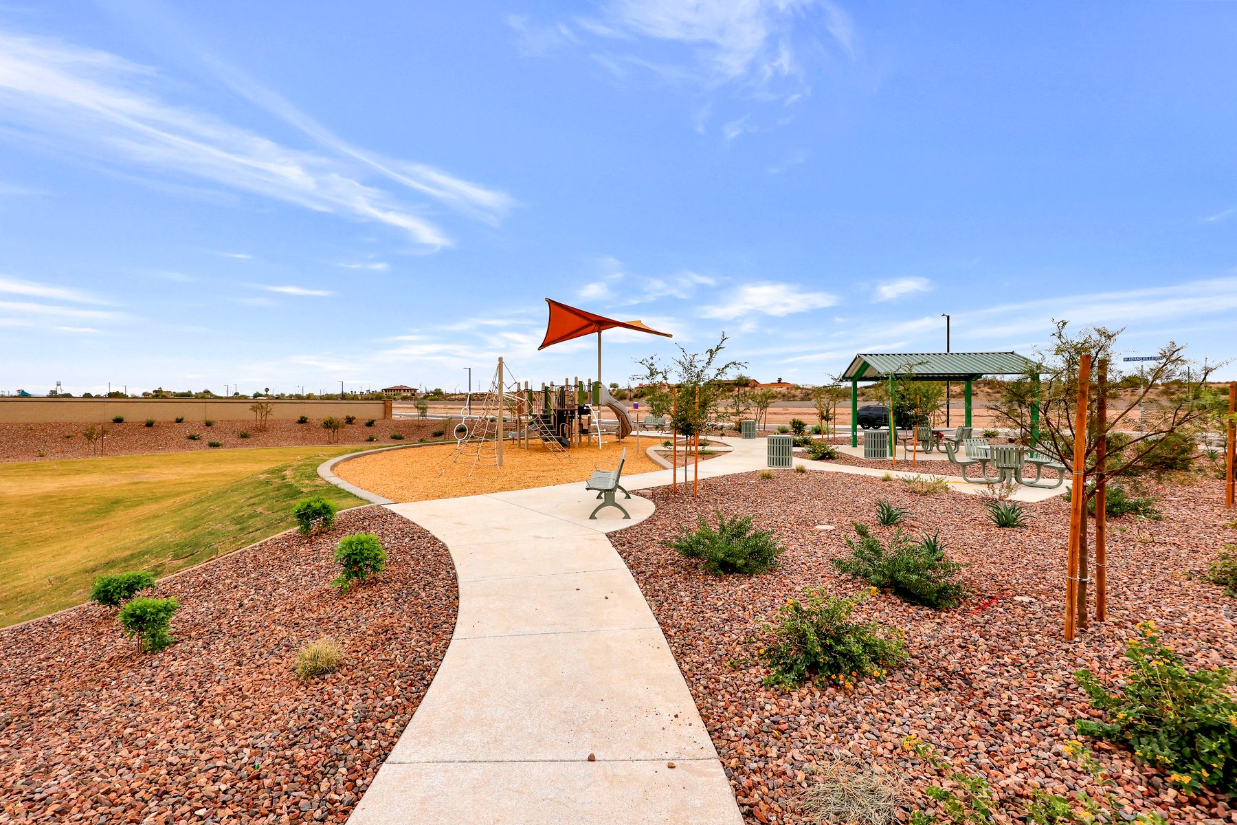 This park offers green space, a playground, a shade ramada, and park benches.