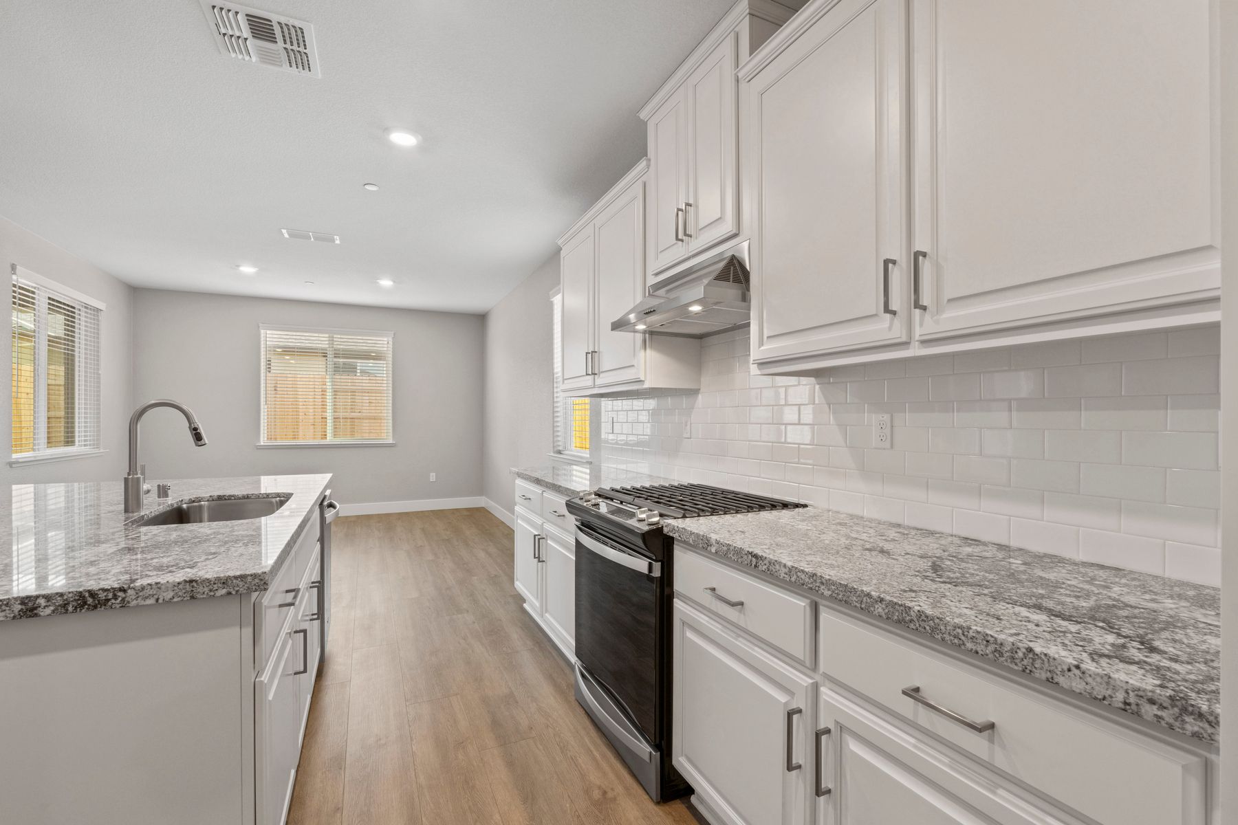 The kitchen has a beautiful white tile backsplash.