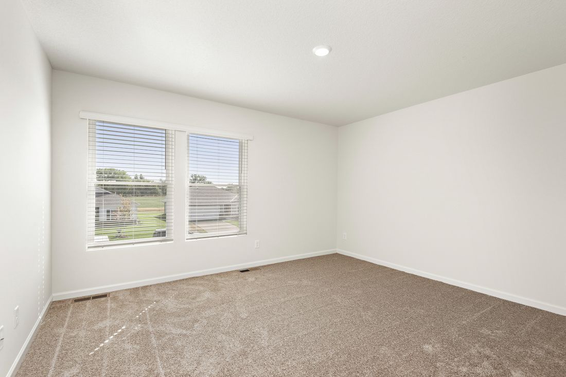 The master bedroom has two large windows and lots of space.