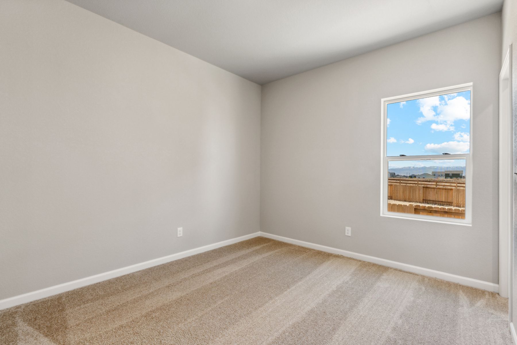 The master bedroom has a large window and lots of space.