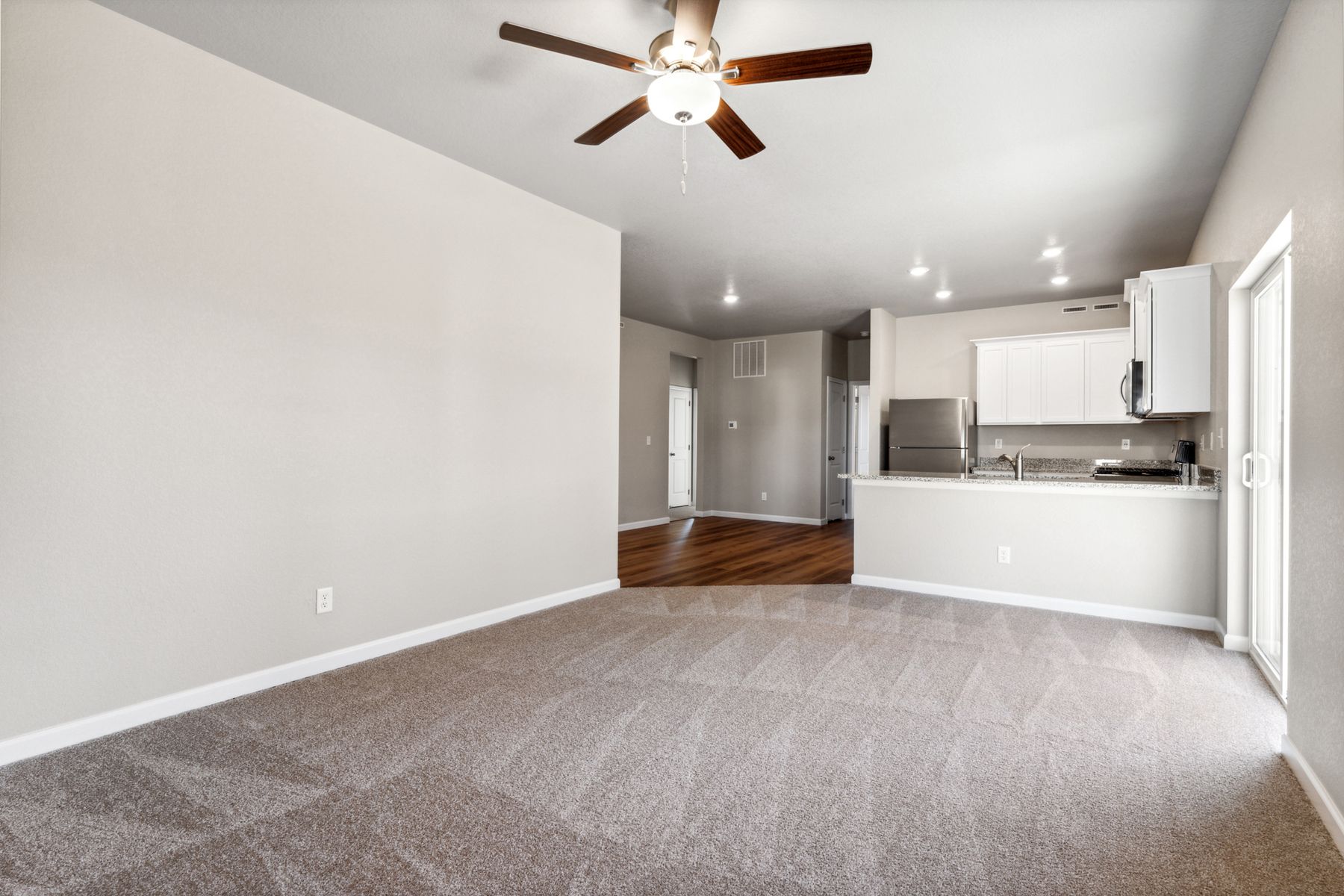 The family room is spacious and has a ceiling fan.