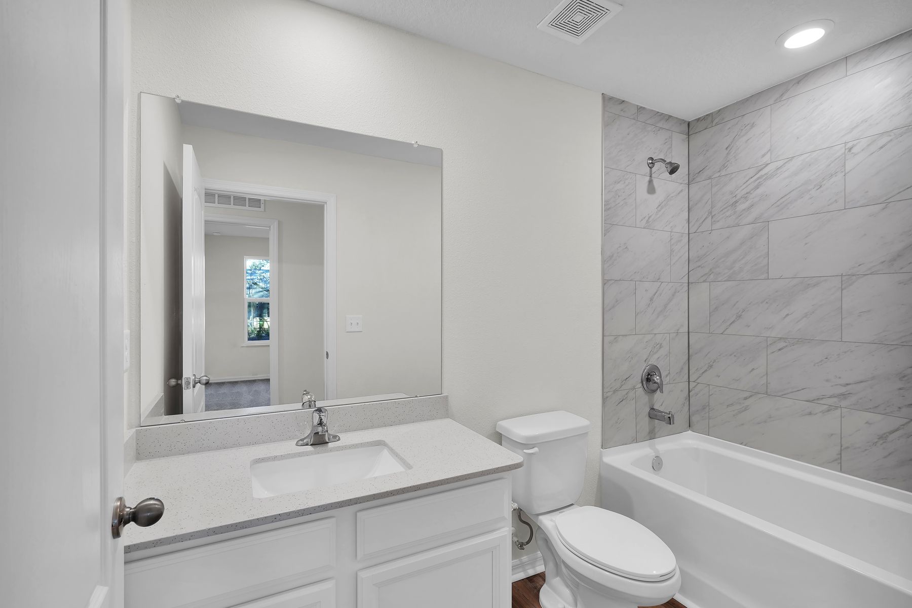 The secondary bathroom has a stunning vanity and a soaker tub.