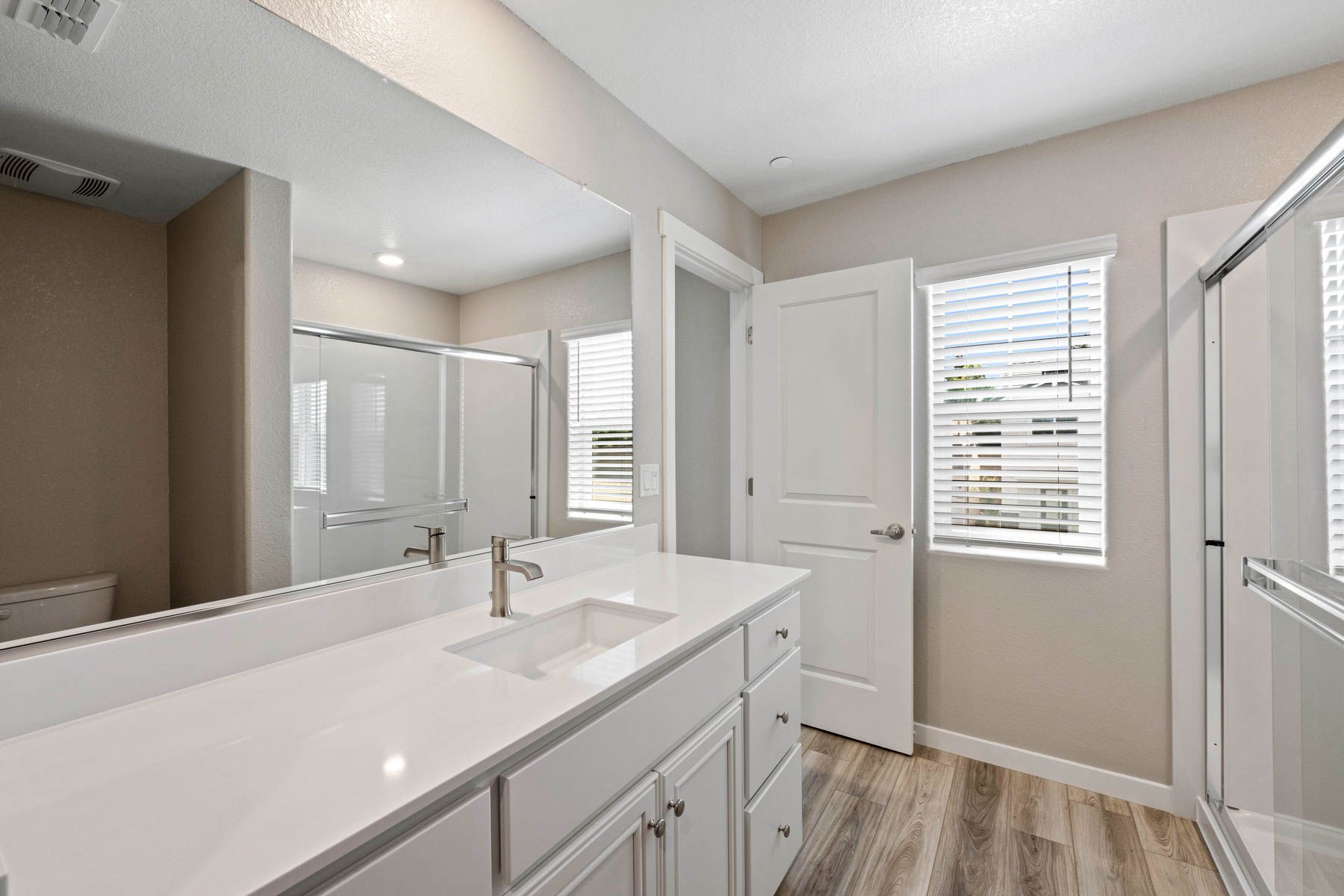 The secondary bathroom has a large vanity and step in shower. 