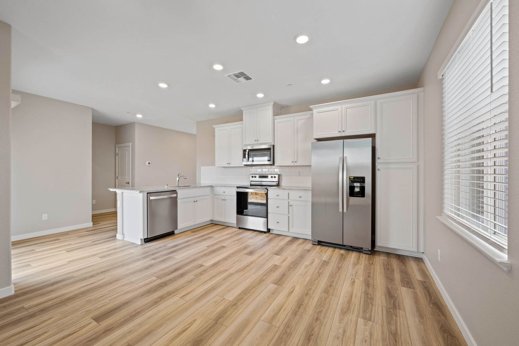 The kitchen is open and has sprawling granite countertops.