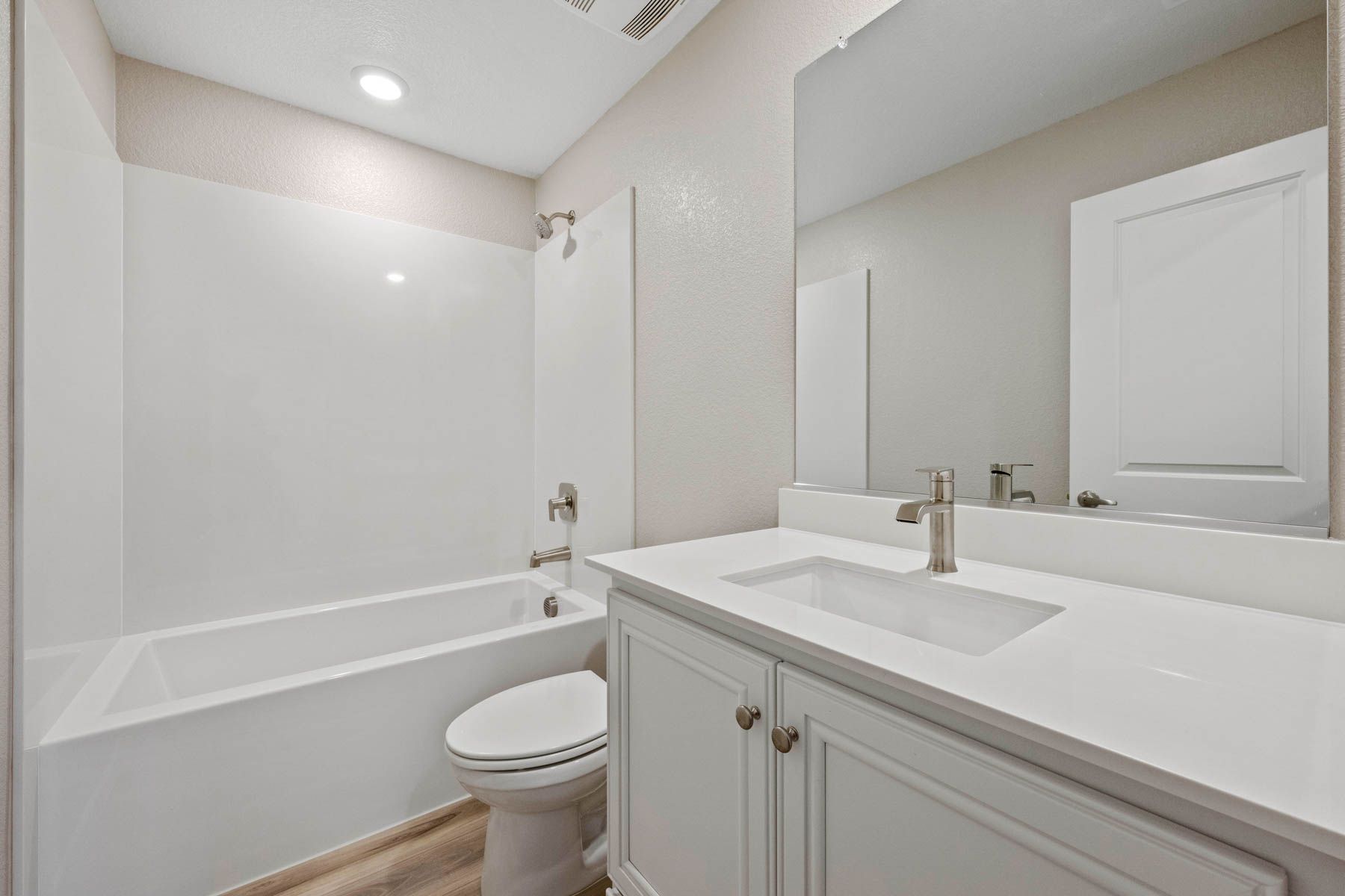 The secondary bathroom has a large vanity and tub/shower combo.