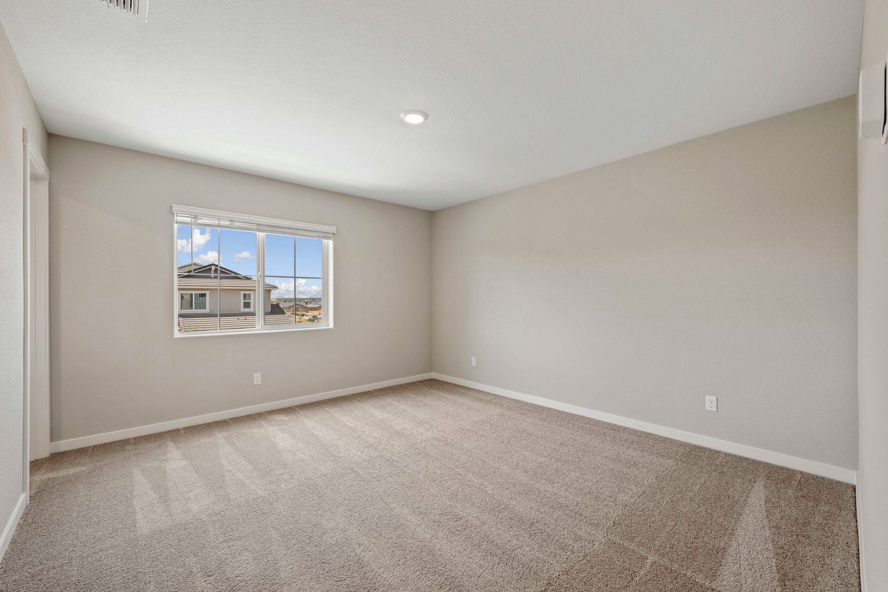 The master bedroom is spacious with a large window.
