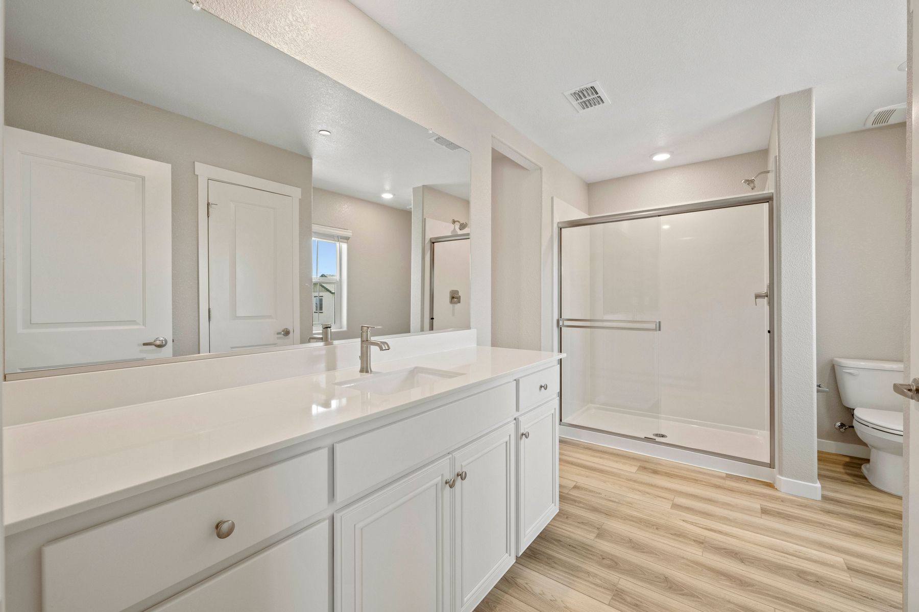 The master bathroom has a large vanity and a step in shower