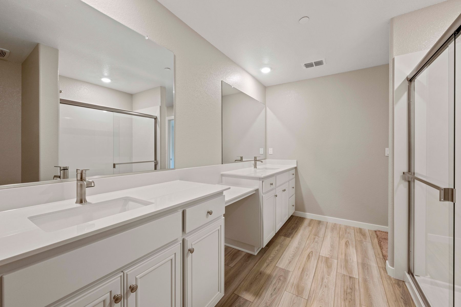 The master bathroom has a dual sink vanity and step in shower.