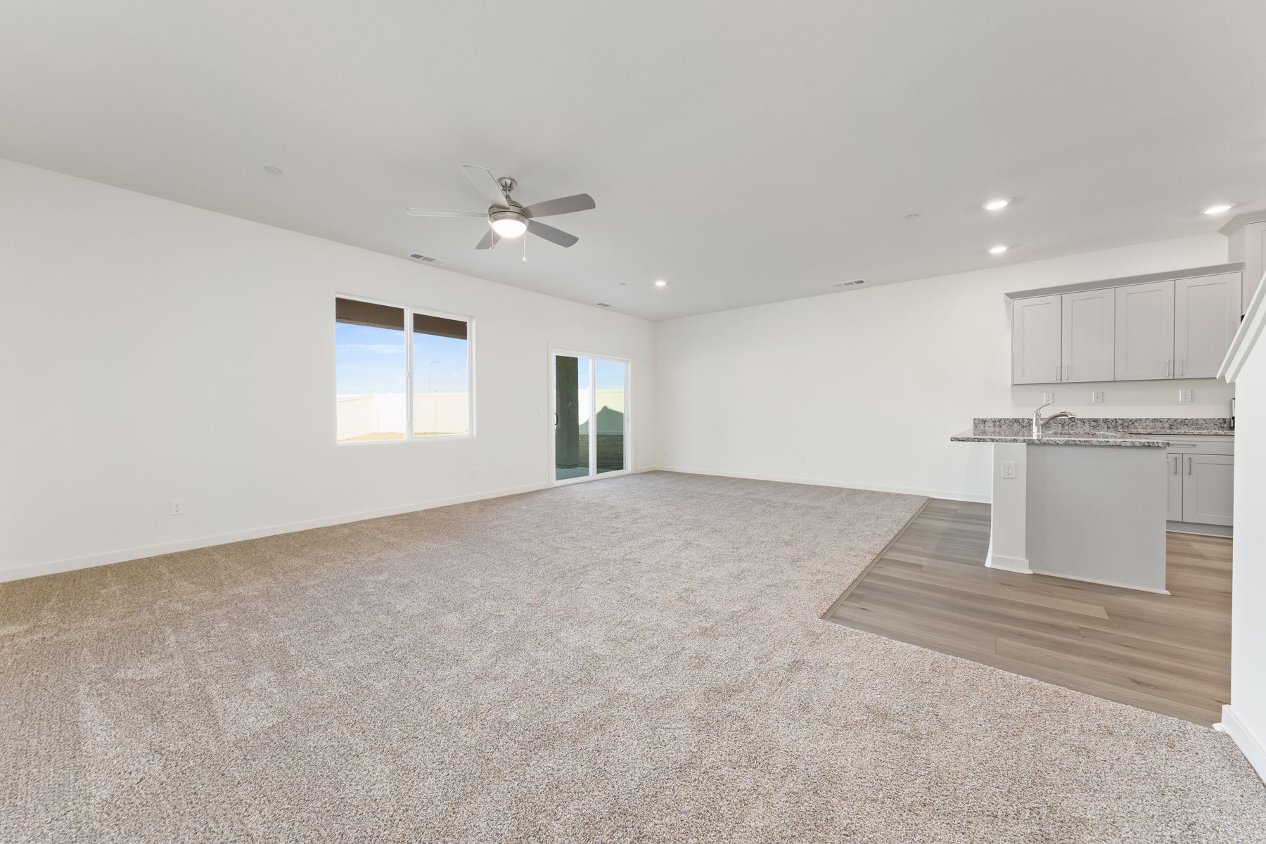 The family room is connected to the kitchen and has a ceiling fan.