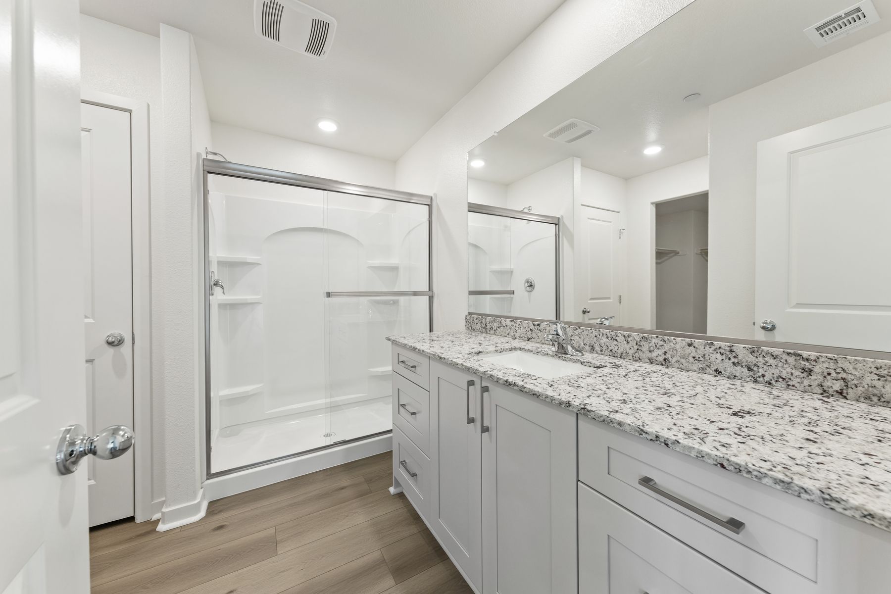 The master bathroom has a large vanity and step in shower. 
