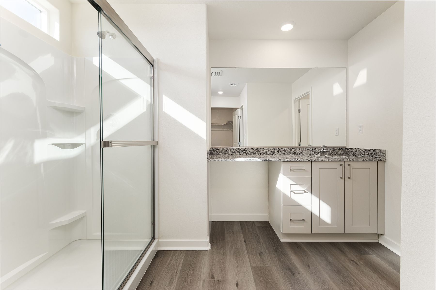 The master bathroom has a large vanity and step in shower. 