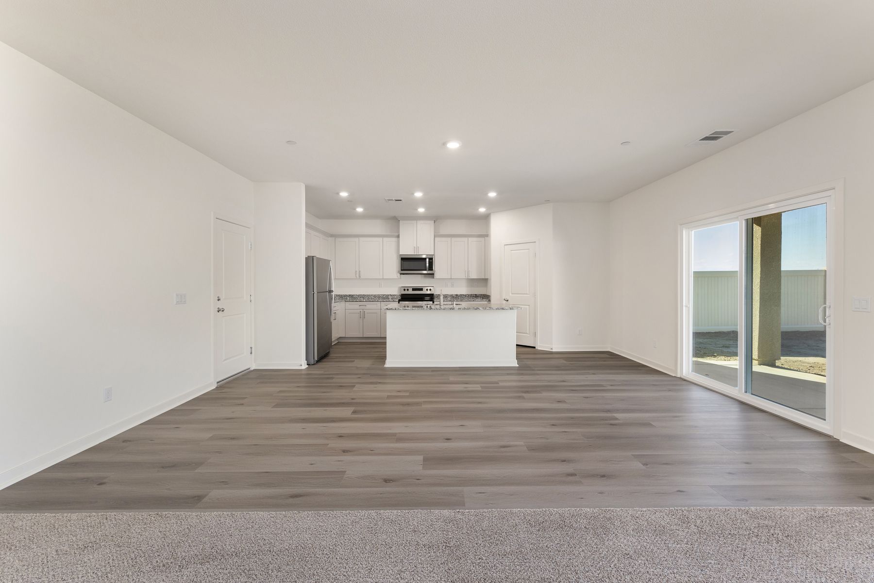 The chef ready kitchen has plank flooring and stainless steel appliances.